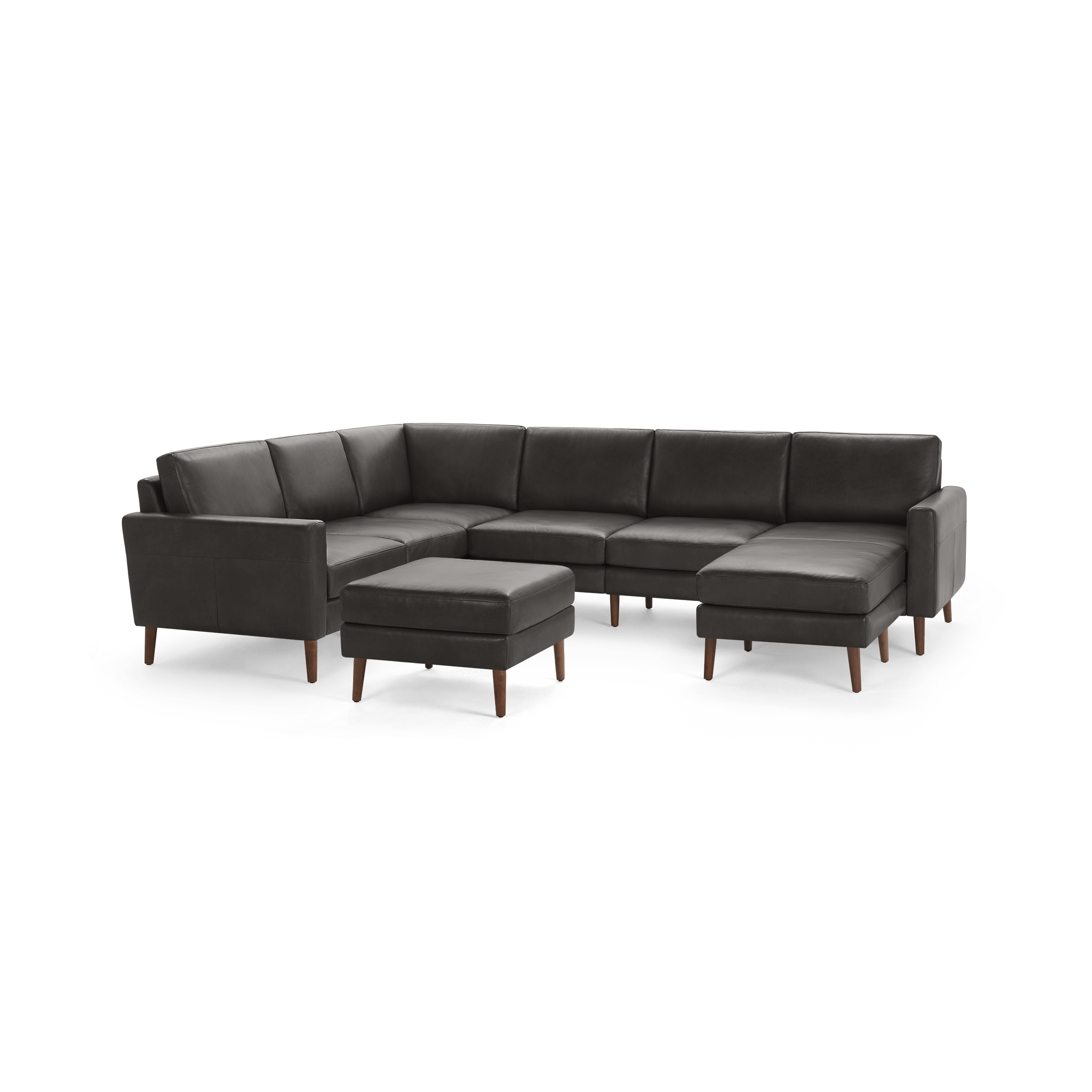 Dark gray leather sectional sofa with wooden legs and matching ottoman, featuring clean lines and modern design.