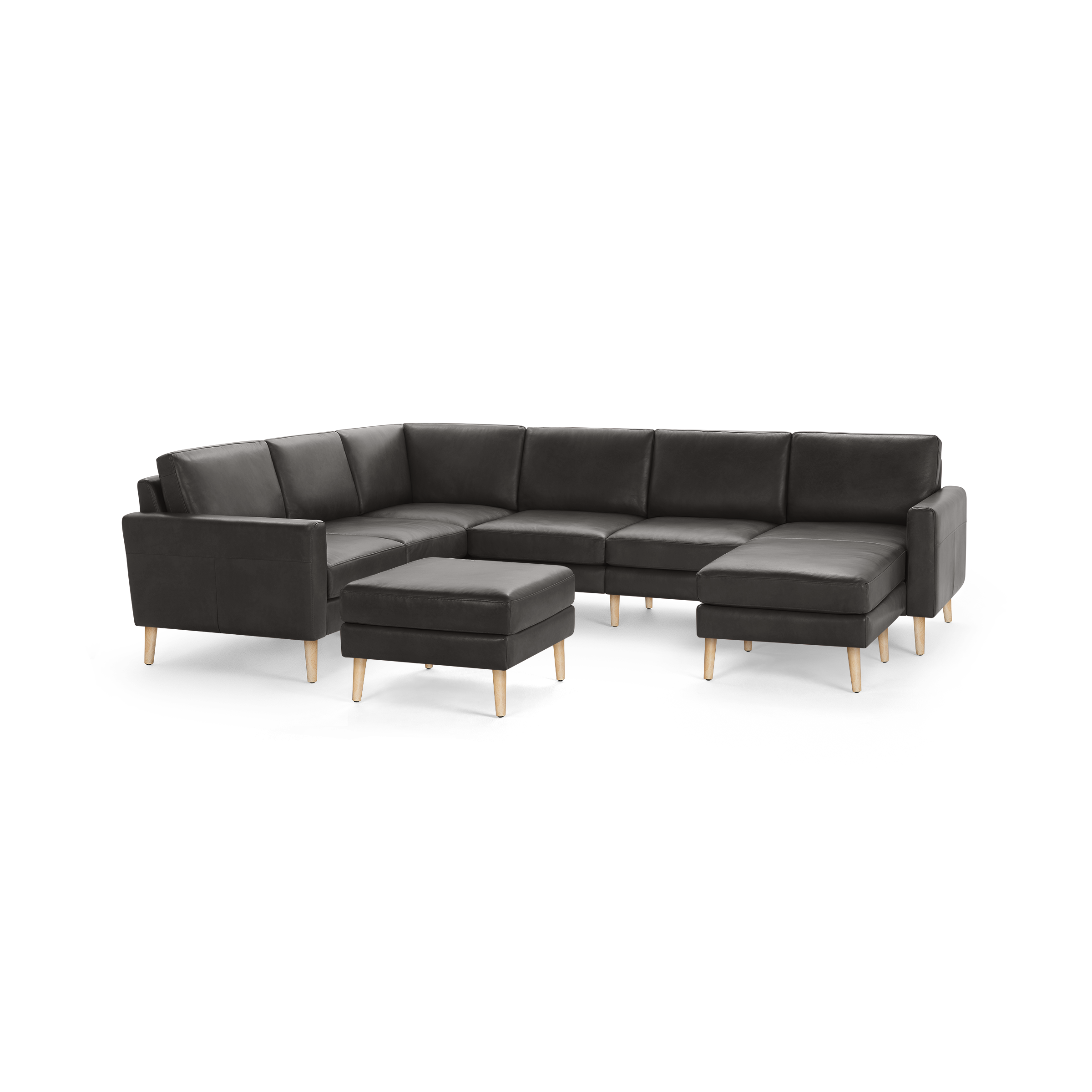 Large modern dark gray sectional sofa with wooden legs and matching ottoman, featuring clean lines and plush cushions.