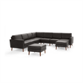 Modern dark gray L-shaped sectional sofa with matching ottoman, wooden tapered legs, and cushioned seating for multiple people.
