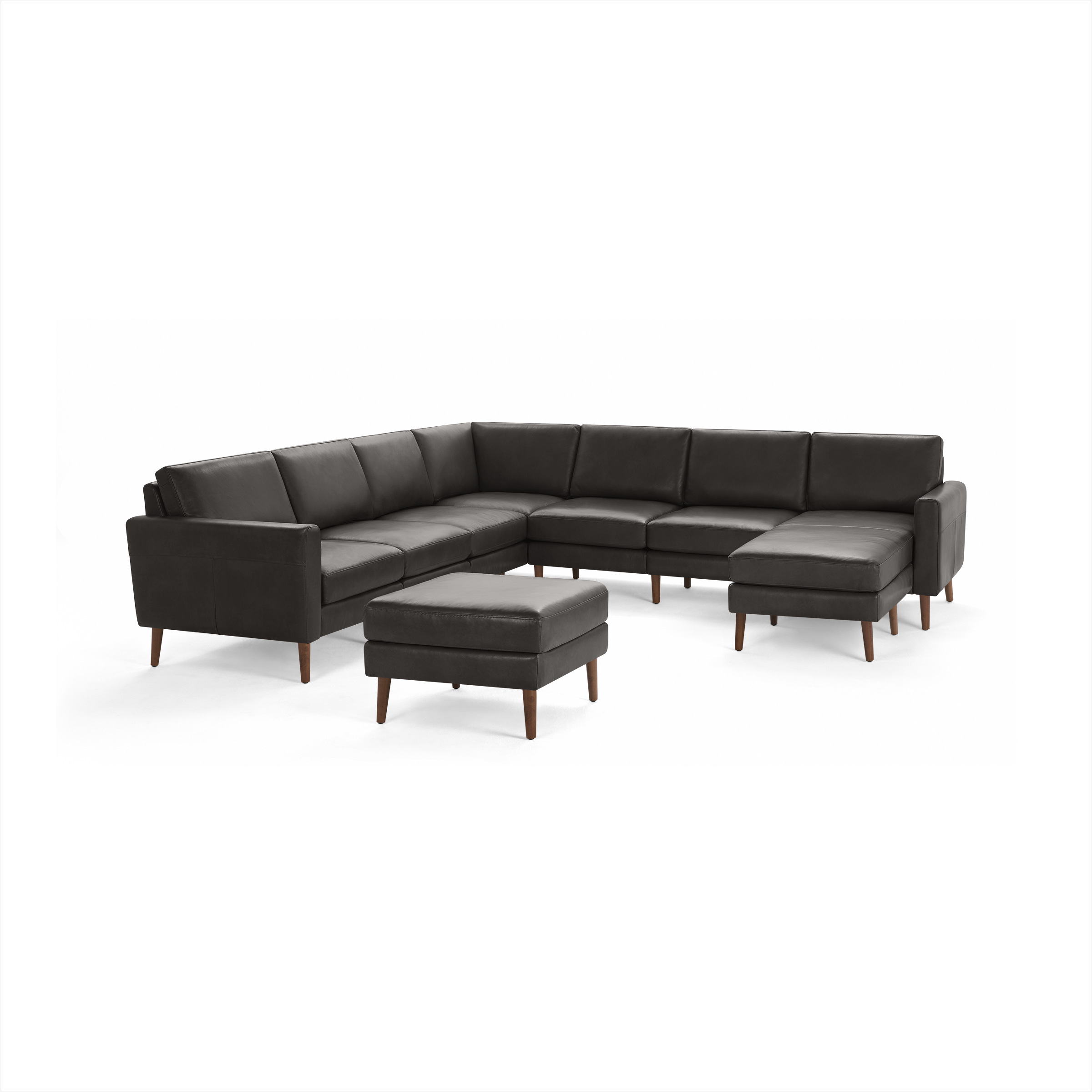 Modern dark gray L-shaped sectional sofa with matching ottoman, wooden tapered legs, and cushioned seating for multiple people.