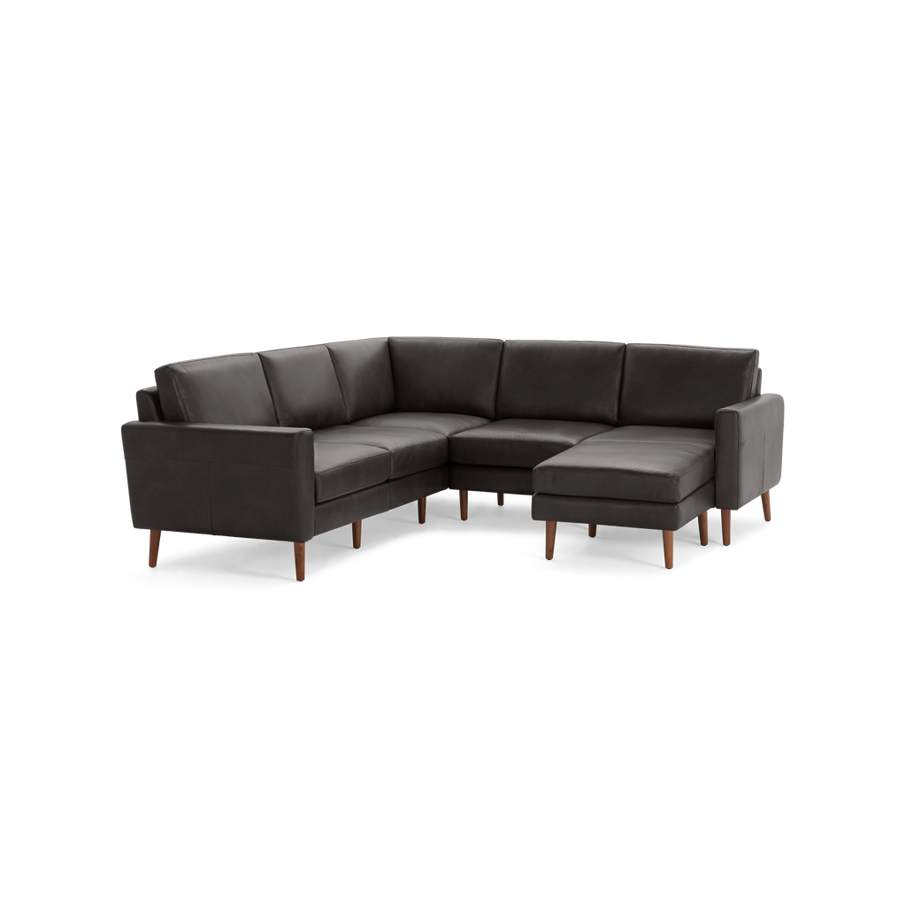 Modern dark gray L-shaped sectional sofa with wooden legs and plush cushions, offering comfortable seating for multiple people.