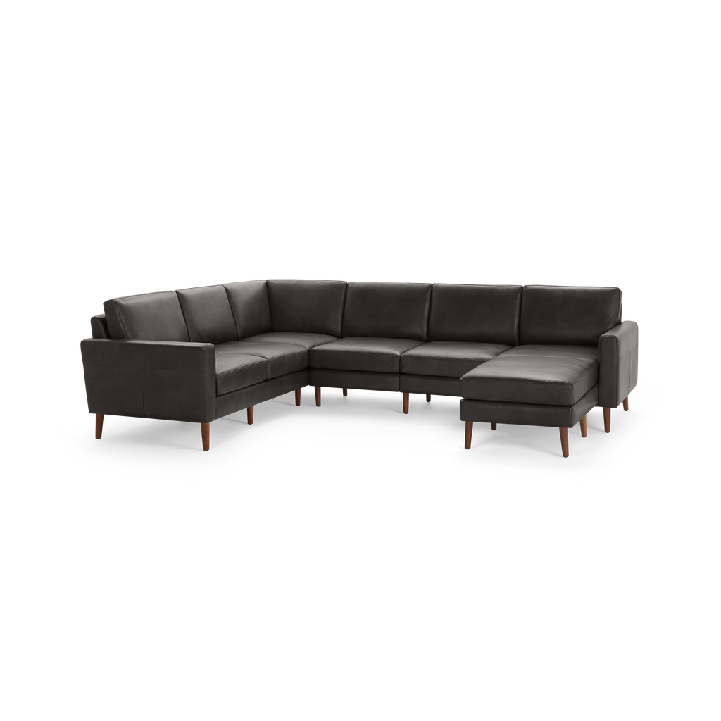 Modern dark gray leather sectional sofa with wooden legs, featuring an L-shaped design and cushioned backrests for comfort.