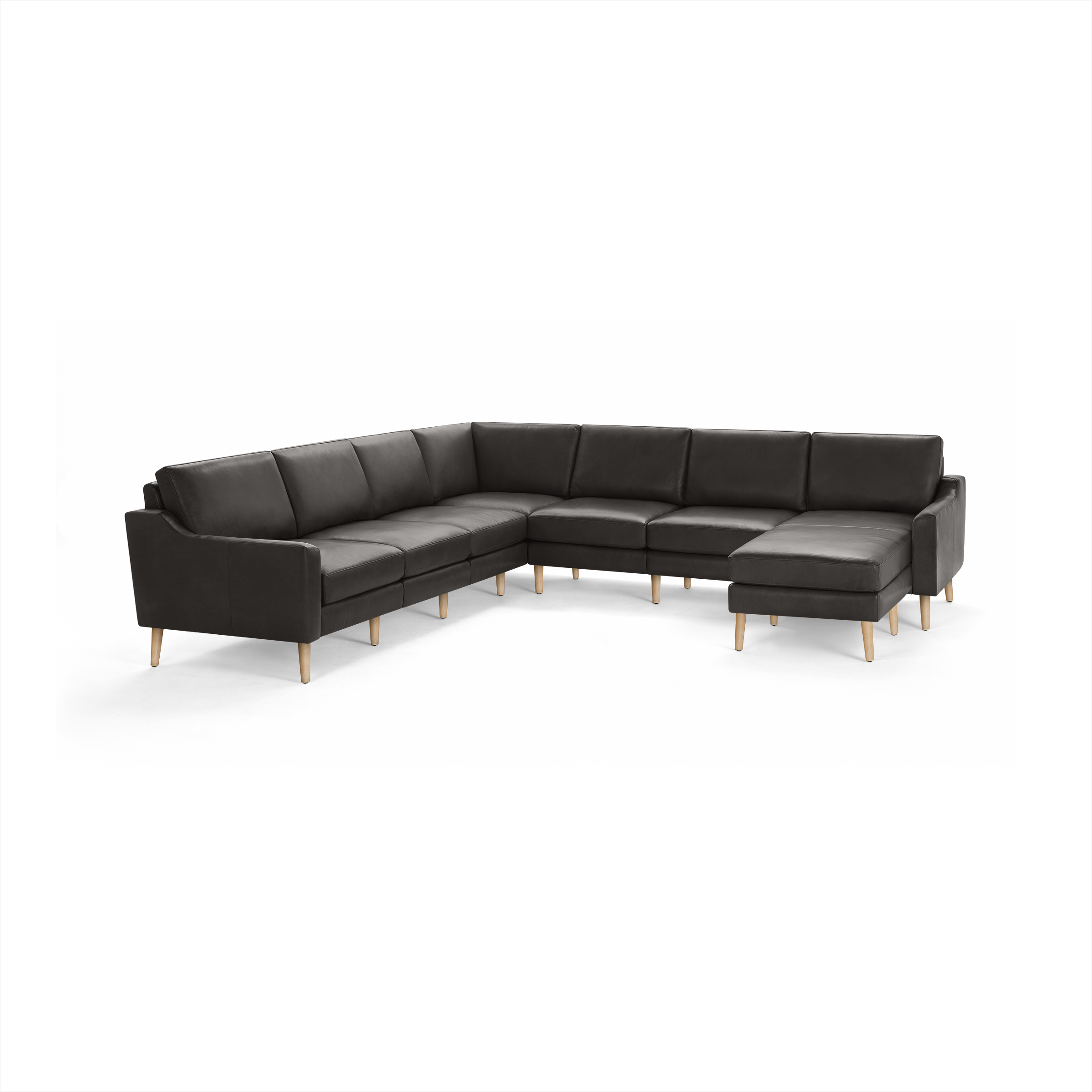 Large modern sectional sofa in dark gray leather with wooden legs and cushioned seats and backrests.