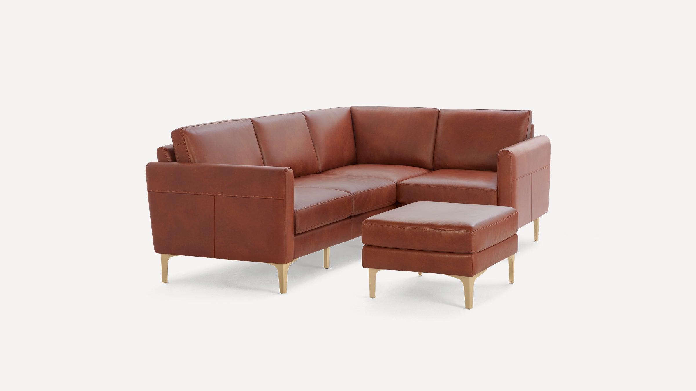 Modern brown leather sectional sofa with clean lines and a matching ottoman on wooden legs, set against a white background.
