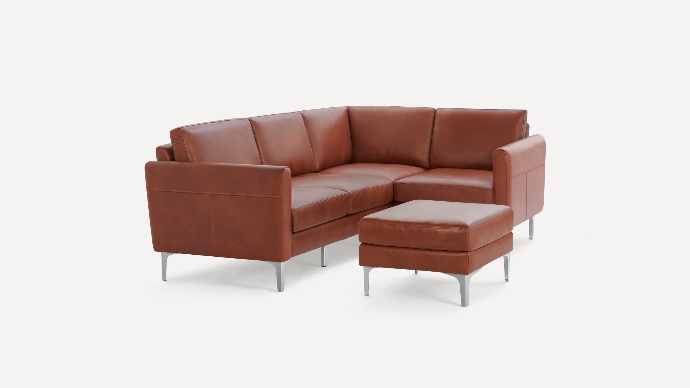 Modern brown leather sectional sofa with silver metal legs and matching square ottoman on white background.