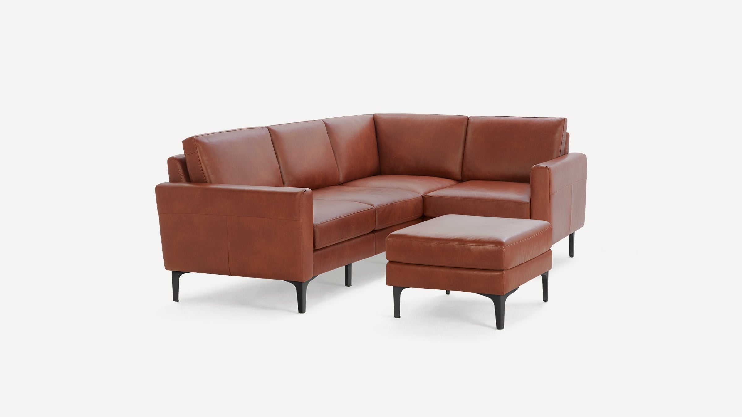 Brown leather L-shaped sectional sofa with clean lines and black metal legs, accompanied by a matching ottoman.