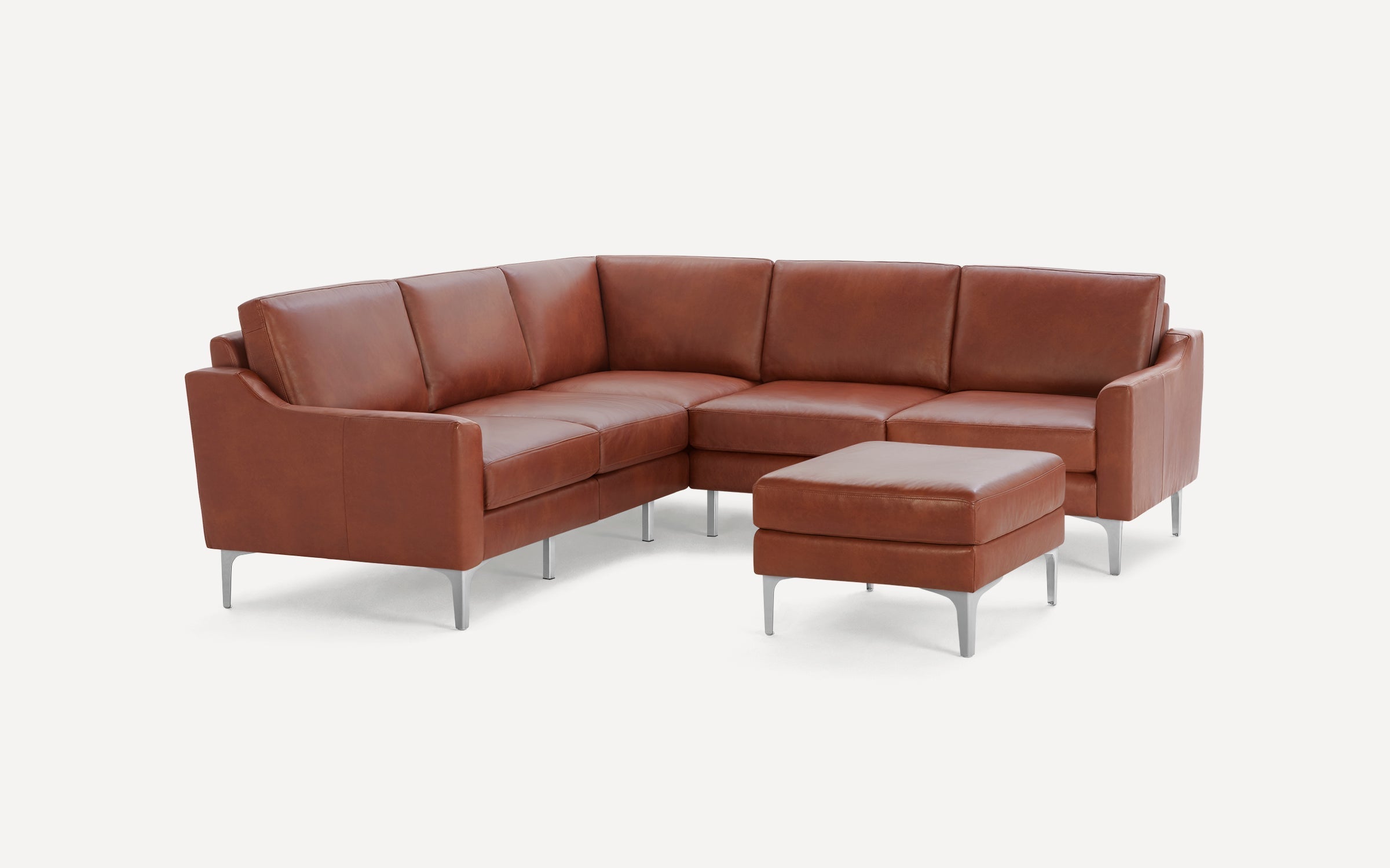 Modern brown leather sectional sofa with sleek metal legs and matching square ottoman, set against a plain white background.
