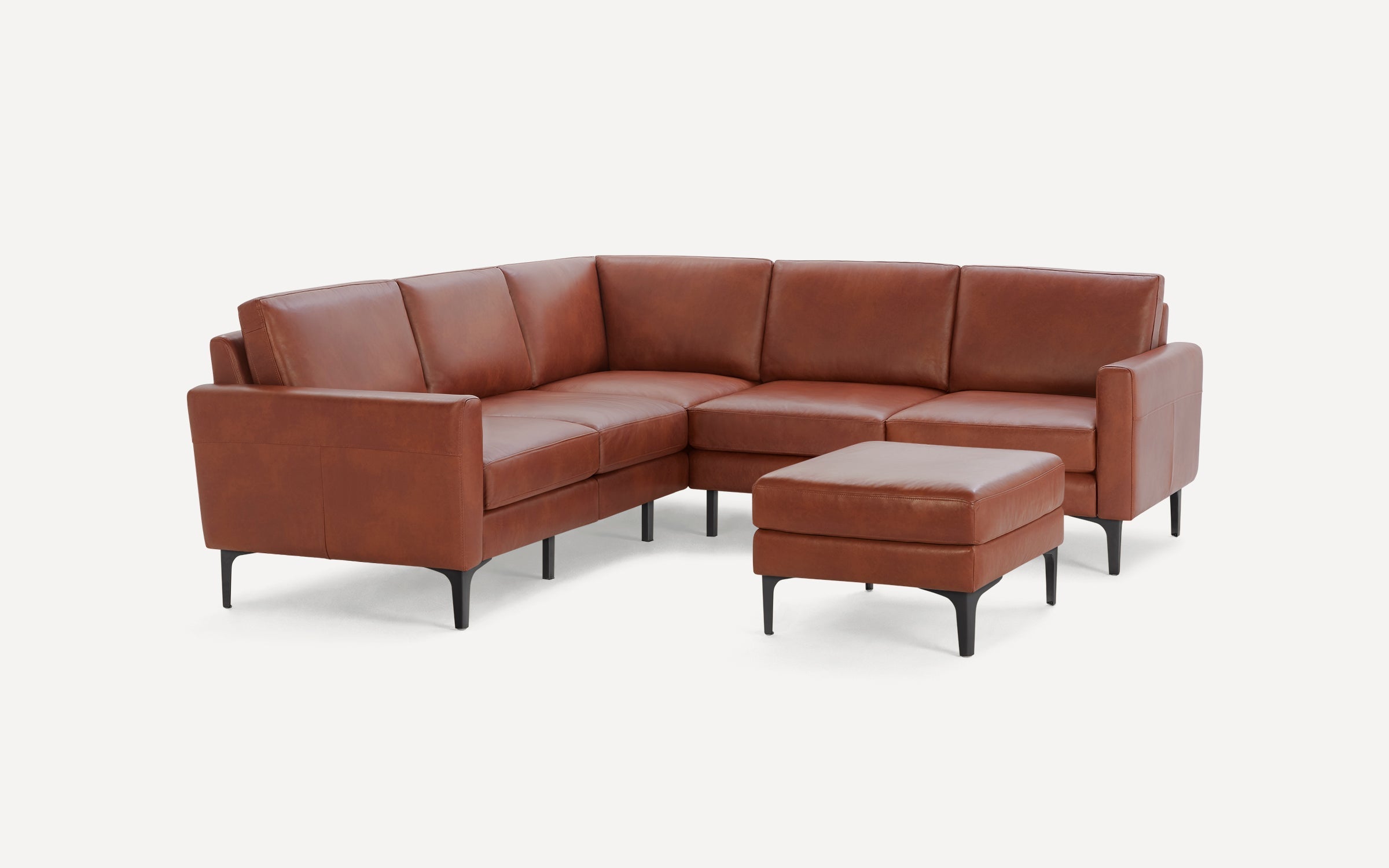 Modern L-shaped brown leather sectional sofa with matching ottoman, featuring black tapered legs and clean, smooth cushions.