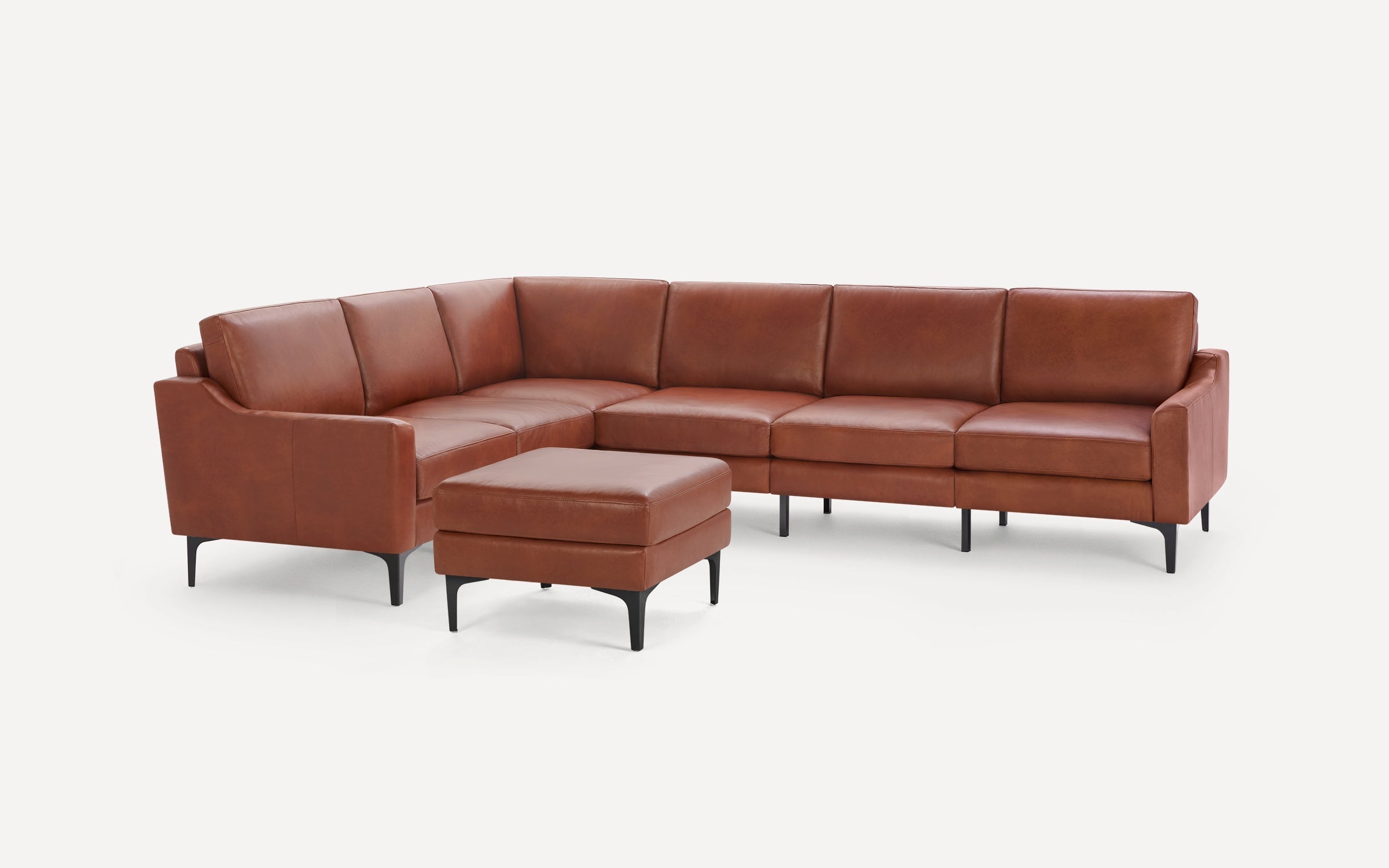 Modern brown leather sectional sofa with clean lines and black metal legs, accompanied by a matching ottoman.