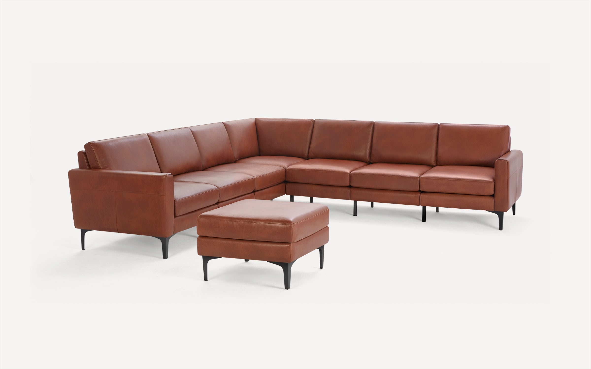 Modern L-shaped brown leather sectional sofa with matching ottoman, slim black legs, and clean lines on white background.