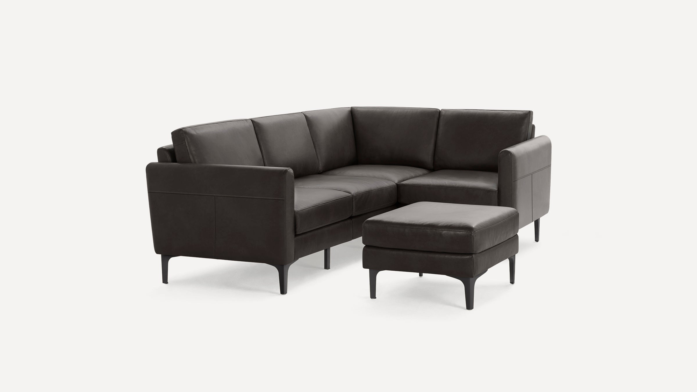 Modern dark gray leather sectional sofa with clean lines and matching ottoman, set against a plain white background.