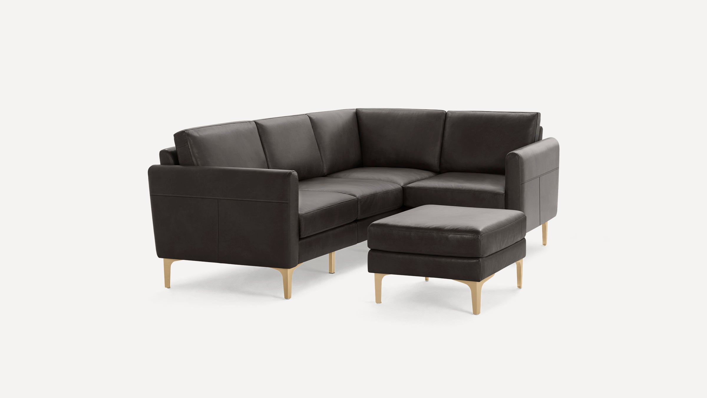 Dark grey leather sectional sofa with clean lines, wooden legs, and a matching ottoman against a white background.