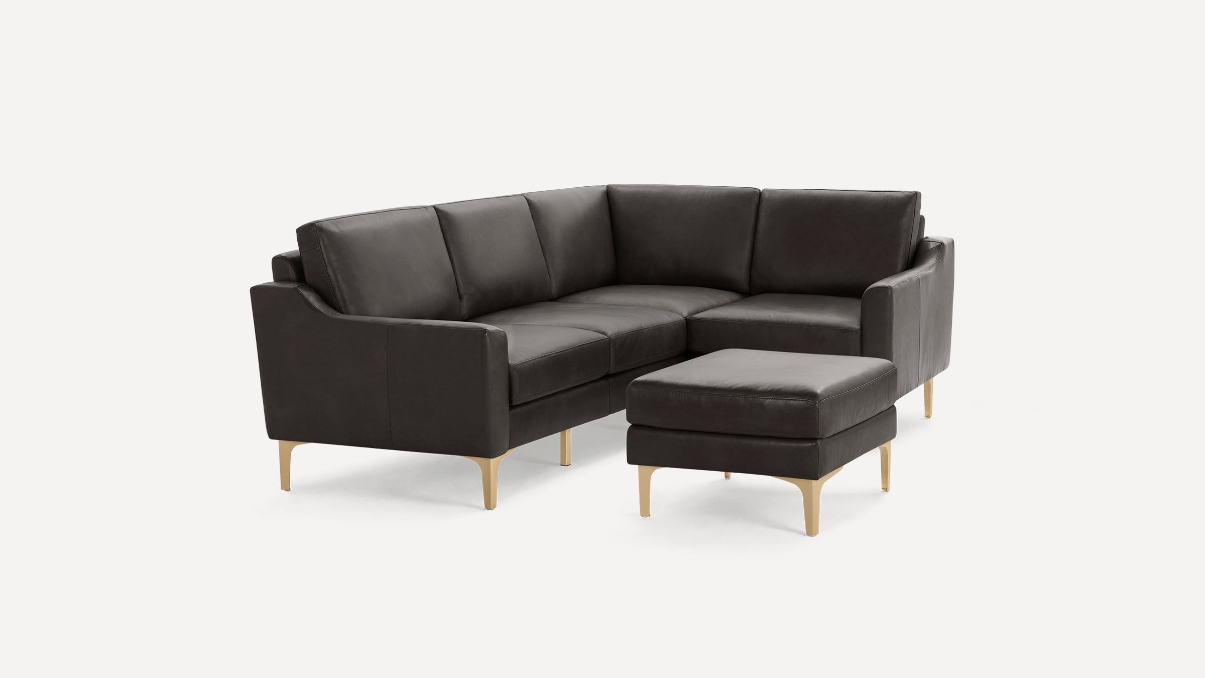Dark brown leather sectional sofa with clean lines, angled backs, slim golden legs, and matching ottoman on a white background.