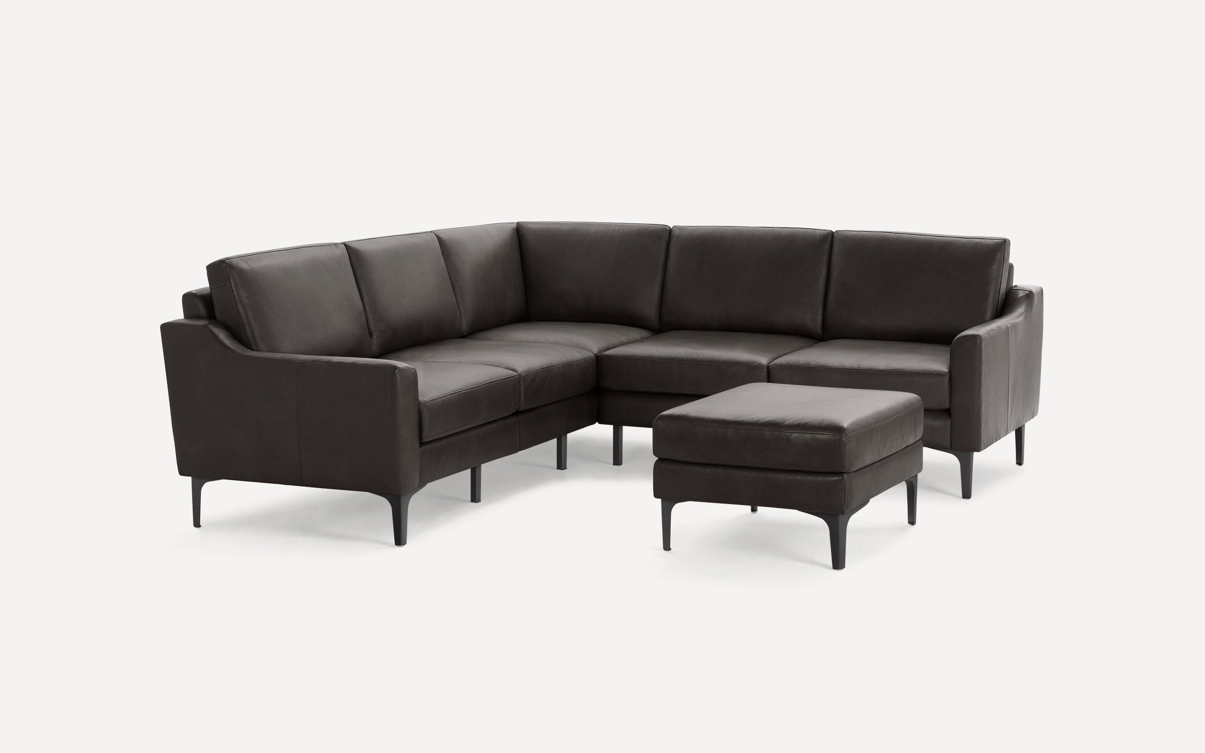 Dark brown leather sectional sofa with clean lines and slim black legs, accompanied by a matching ottoman.