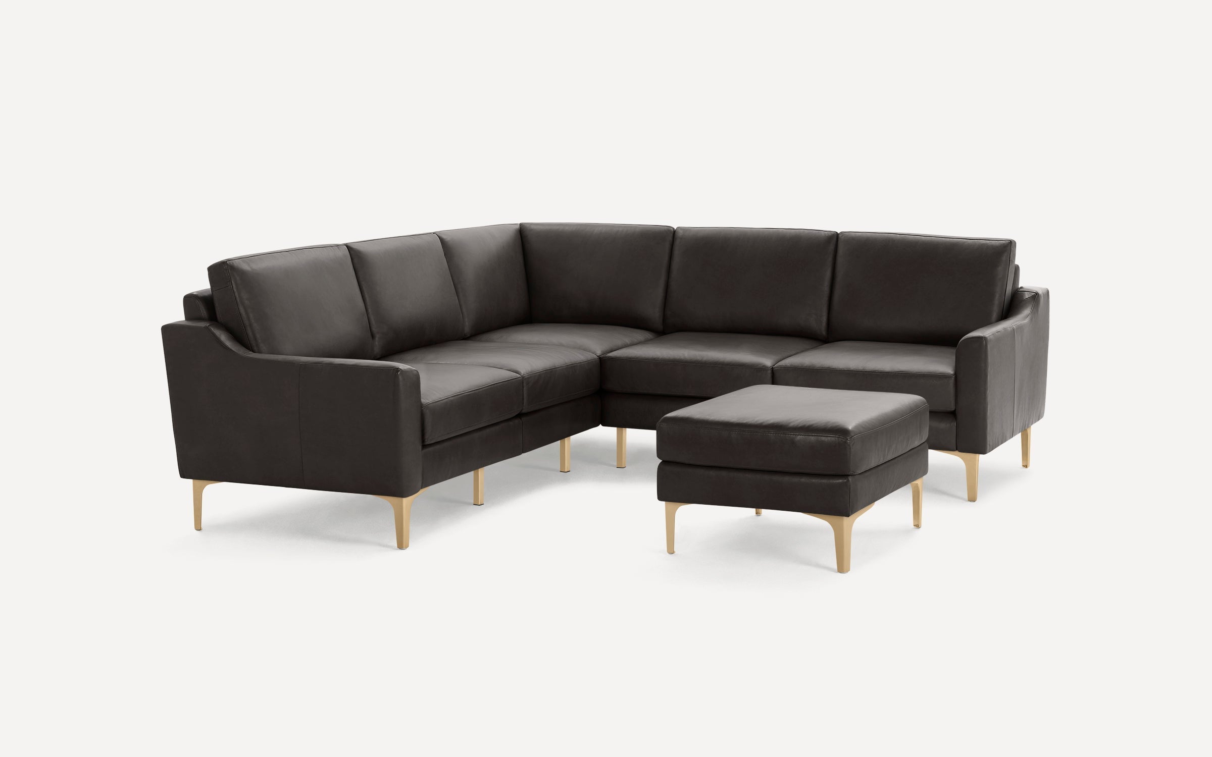 Dark brown leather sectional sofa with matching ottoman, featuring sleek light wooden legs and modern design.