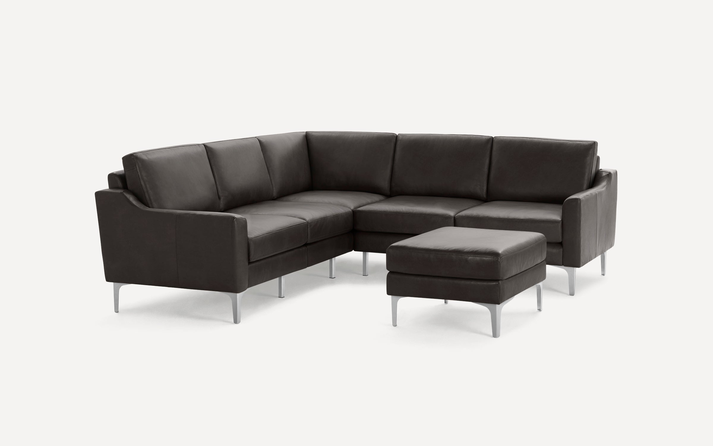Dark brown leather L-shaped sectional sofa with matching ottoman, slim silver metal legs, and modern design against white background.