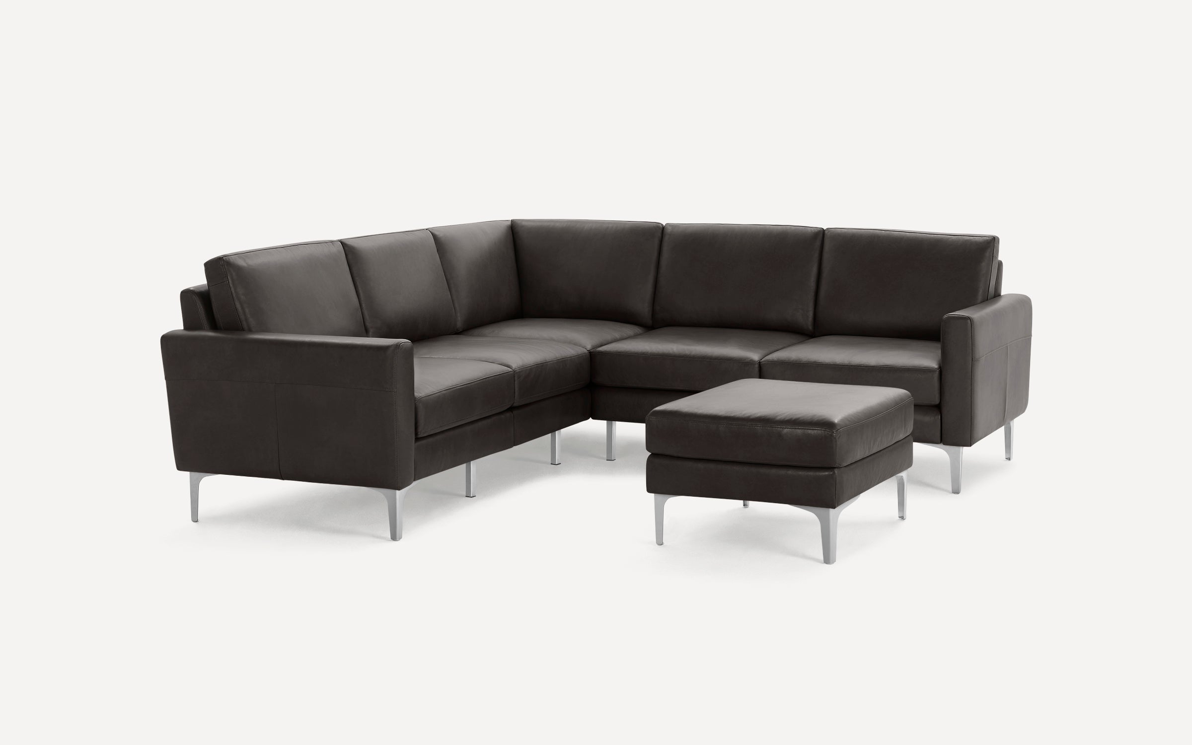 Modern dark gray leather L-shaped sectional sofa with matching ottoman, featuring sleek metal legs and clean lines.