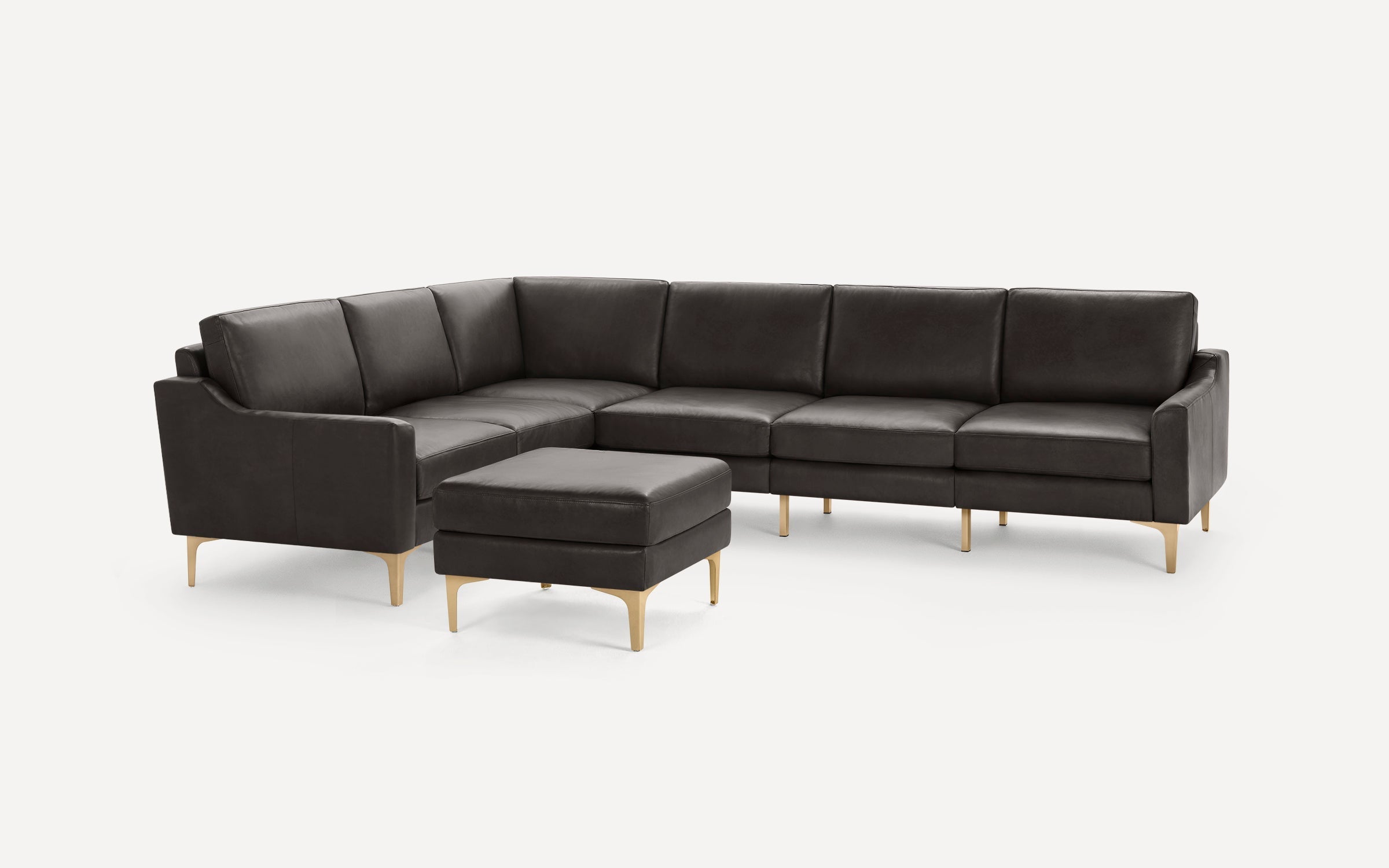 Dark brown leather L-shaped sectional sofa with matching ottoman and slim gold metal legs on plain white background.