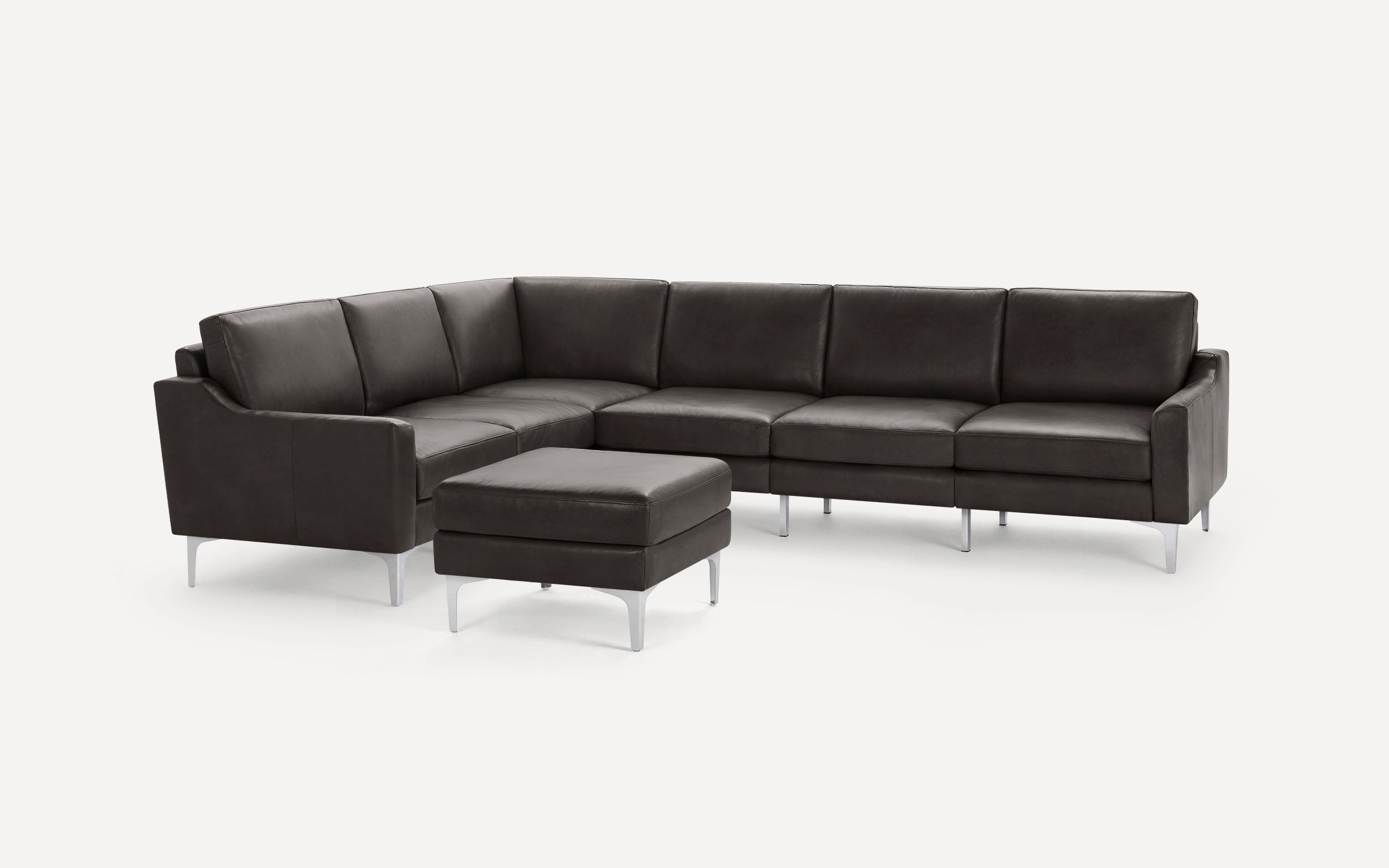 Dark brown leather sectional sofa with metal legs and matching ottoman, modern and minimalist design.