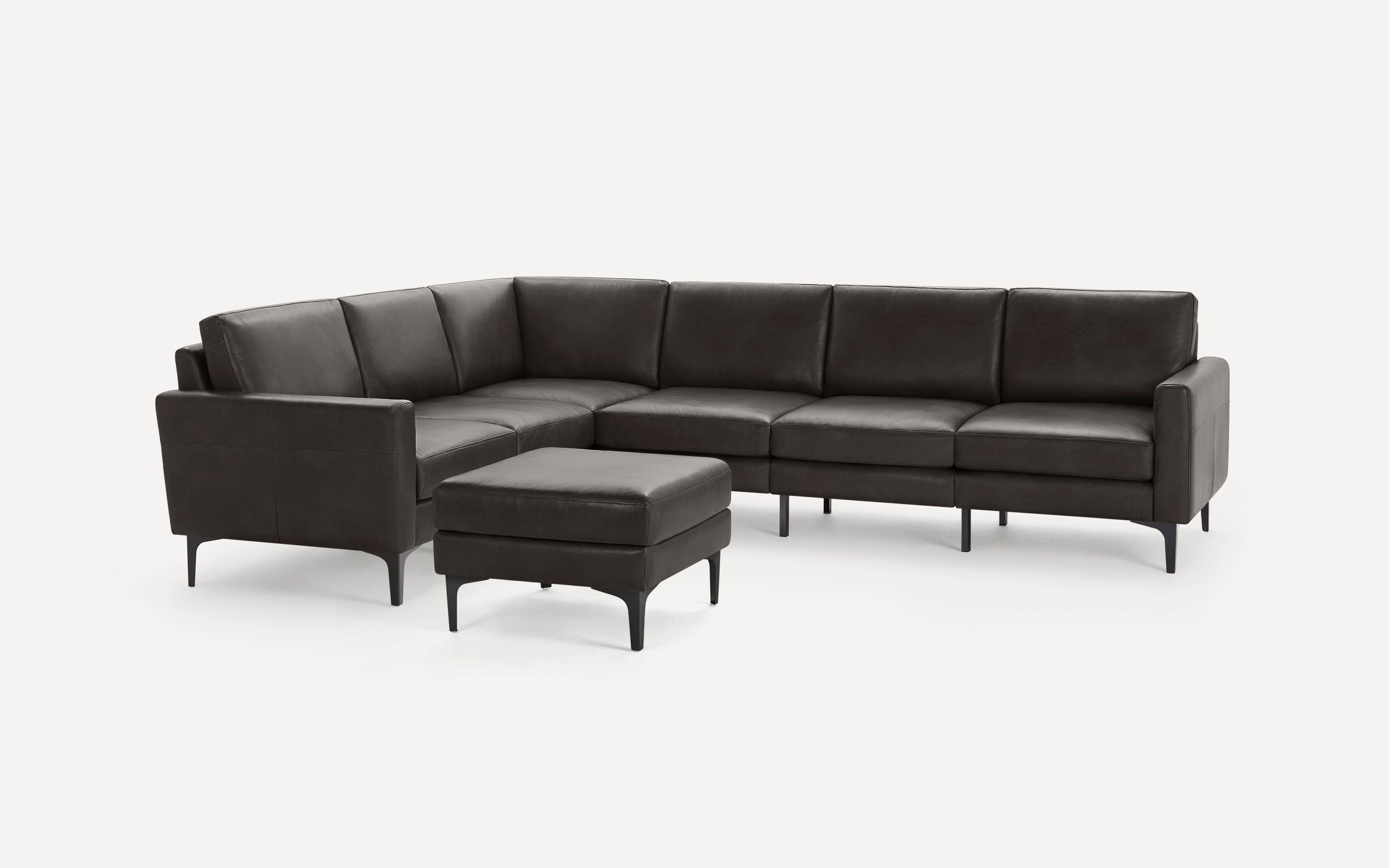 Modern dark brown leather sectional sofa with clean lines and matching ottoman, supported by slim black metal legs.