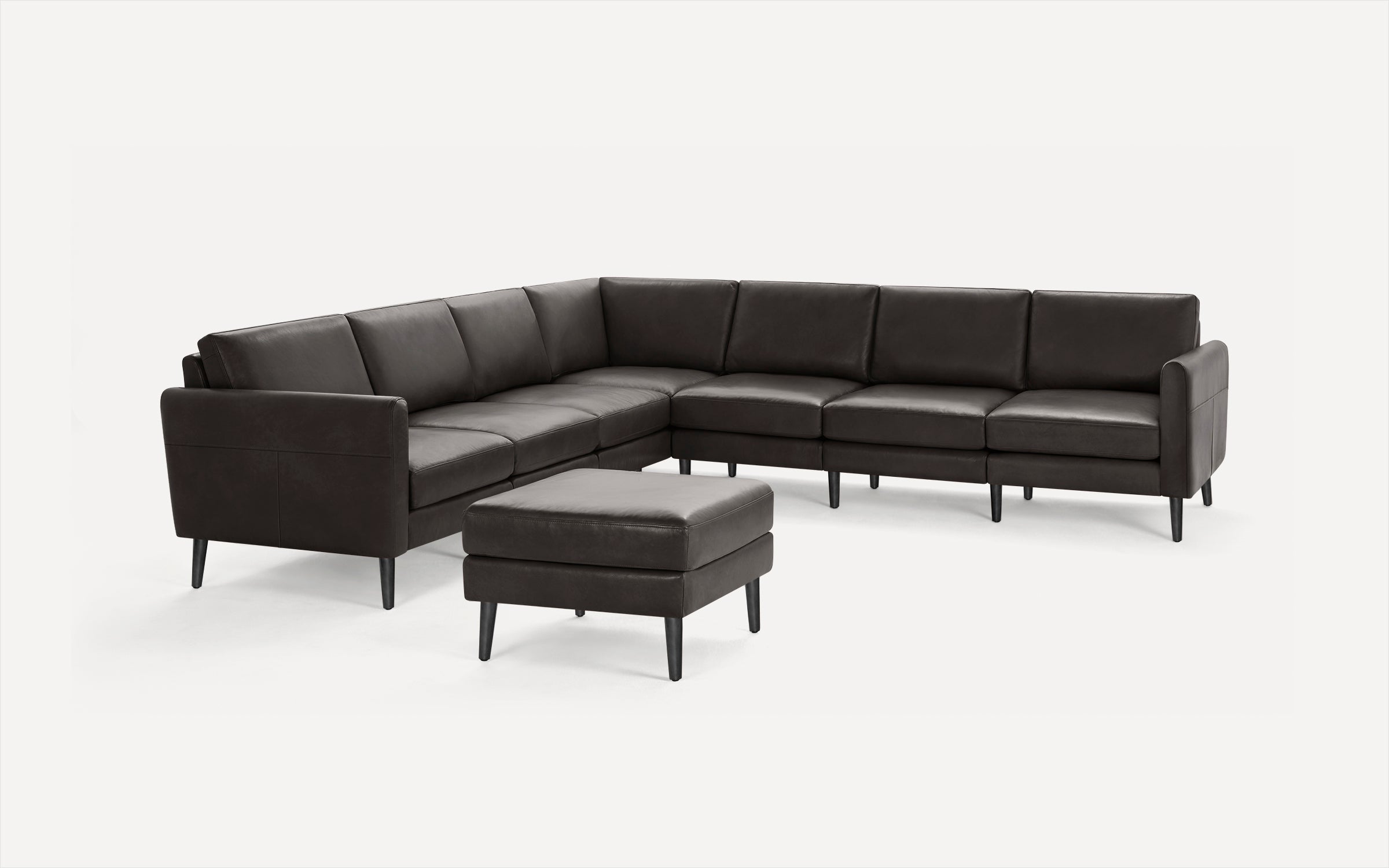 Modern dark brown leather sectional sofa with clean lines and matching square ottoman on tapered black legs.