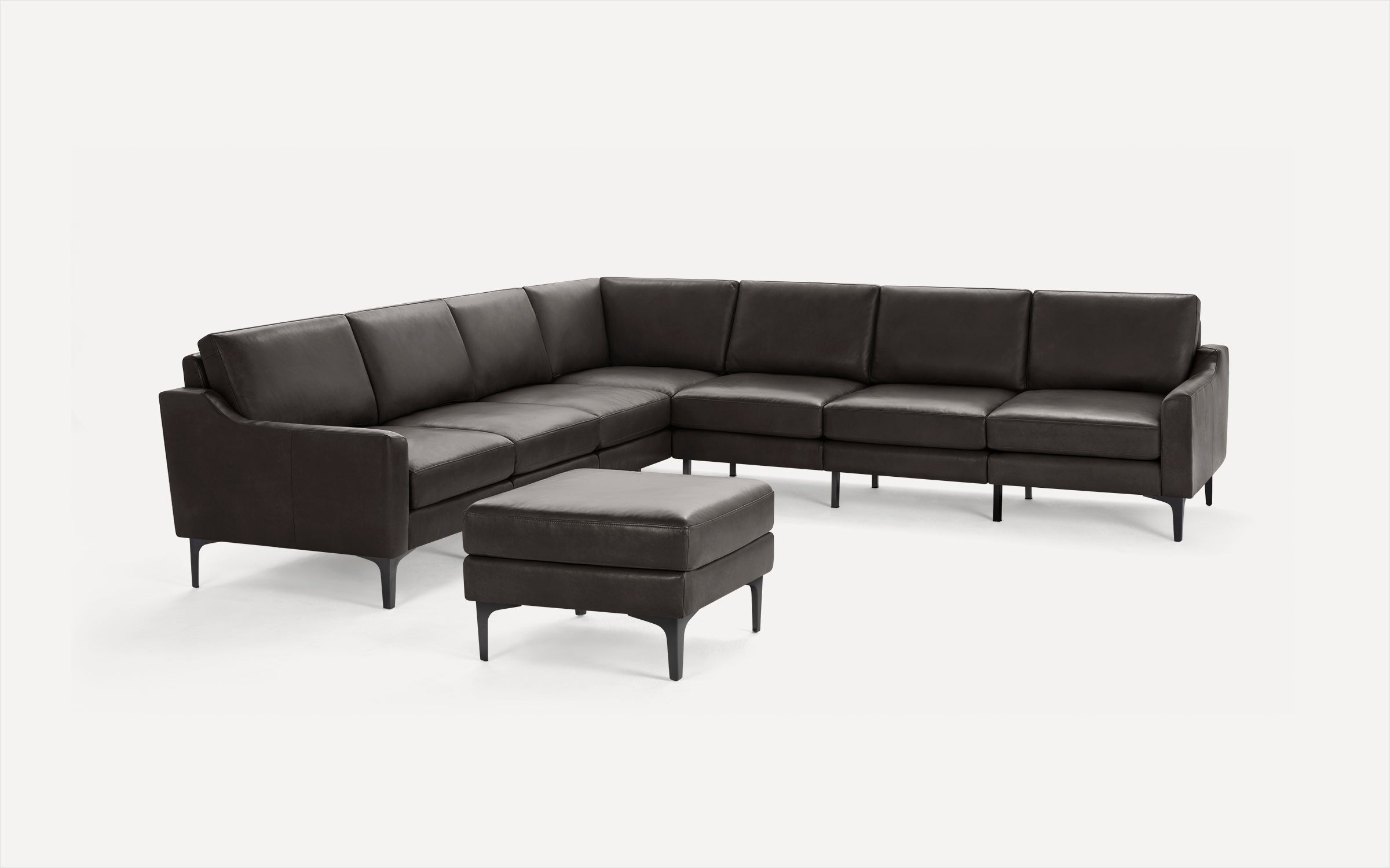 Modern dark brown leather sectional sofa with clean lines and matching ottoman, set on black legs against white background.