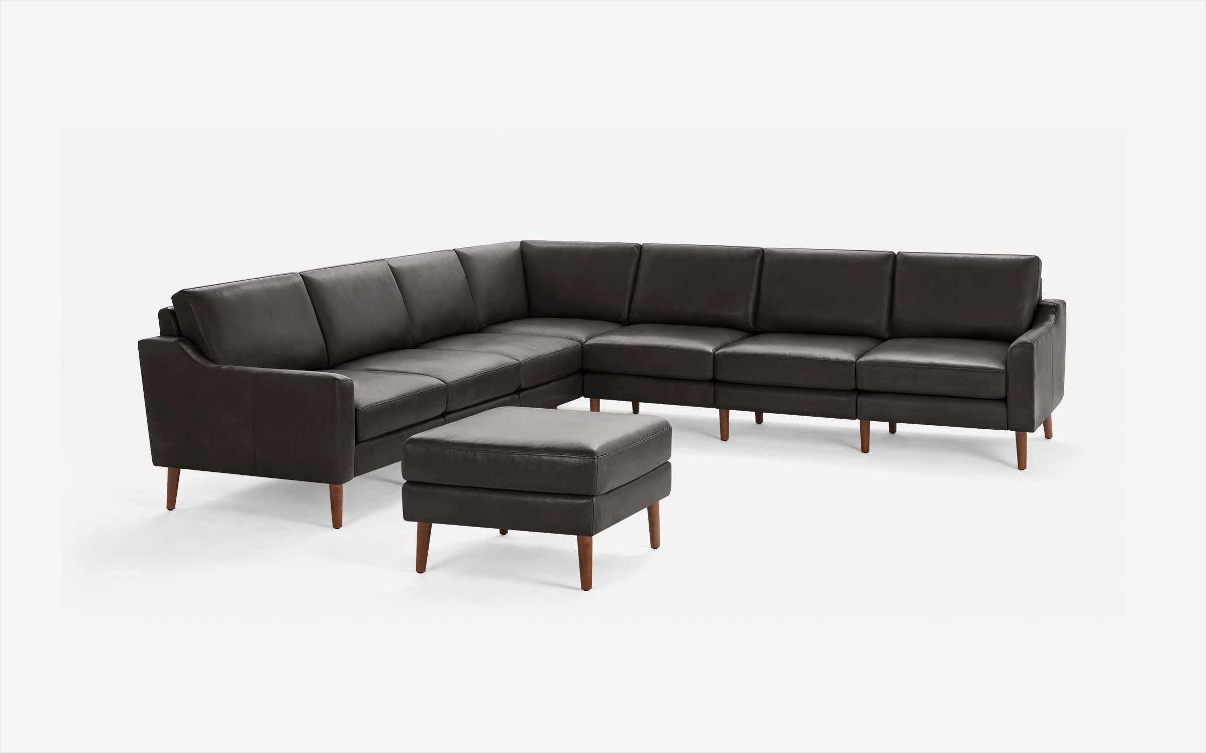 Dark brown leather L-shaped sectional sofa with matching ottoman, clean lines, and wooden tapered legs, modern and minimalist design.