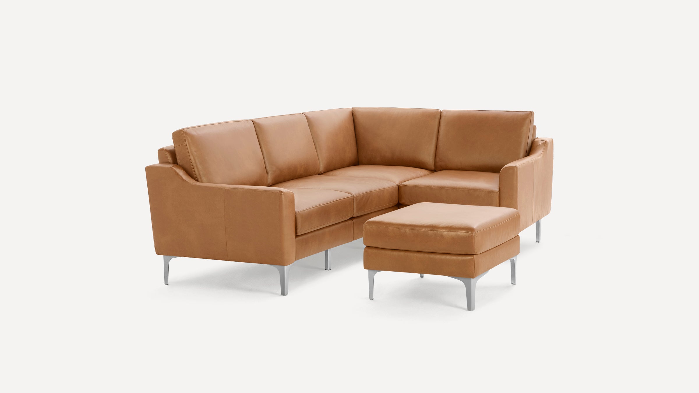 Modern L-shaped tan leather sectional sofa with clean lines and metal legs, accompanied by a matching ottoman.