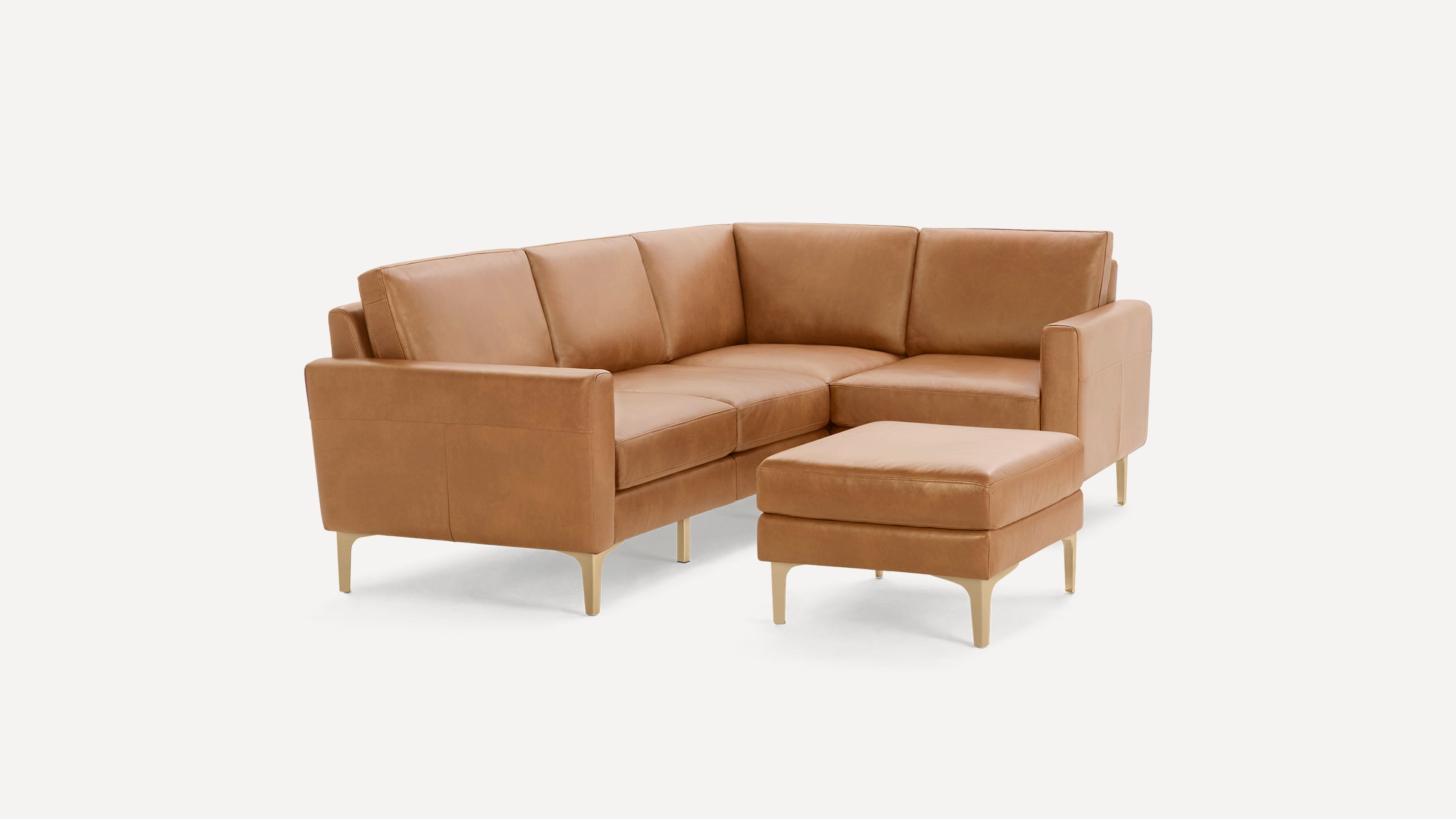 Modern tan leather sectional sofa with clean lines and matching ottoman on light background.