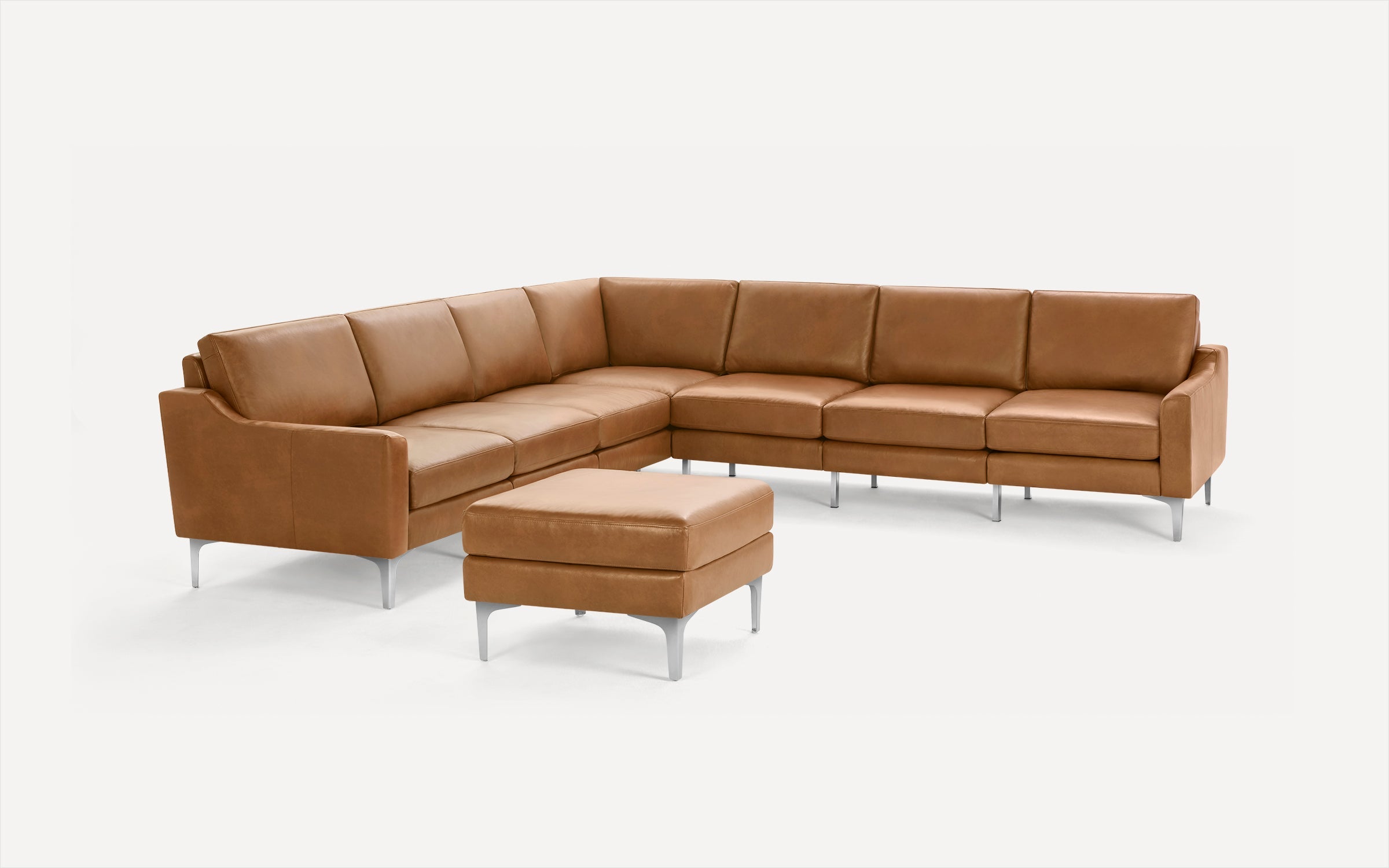 Modern brown leather sectional sofa with sleek metal legs and matching ottoman, shown against white background.