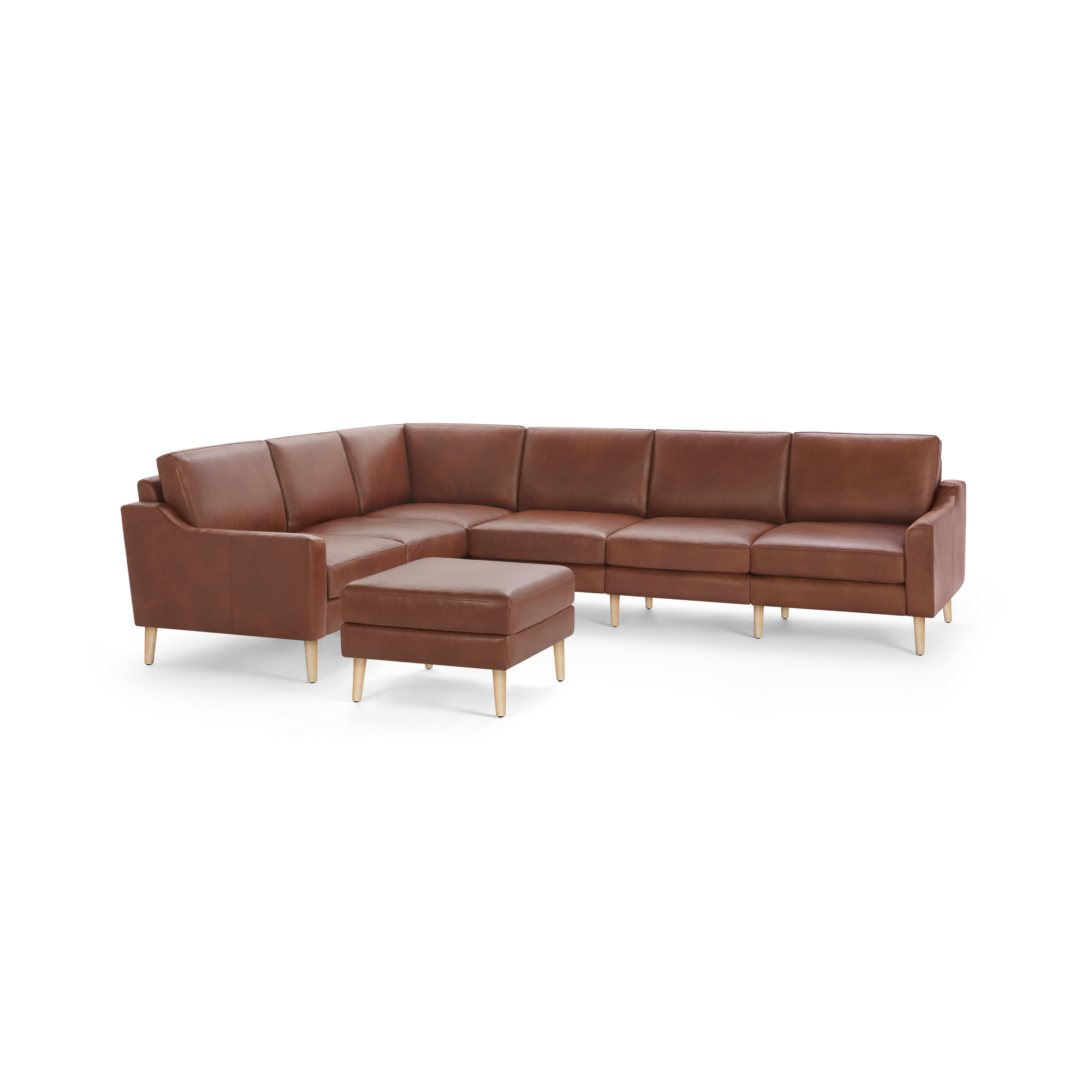 Large brown leather sectional sofa with wooden legs and matching square ottoman, modern and minimalist design.