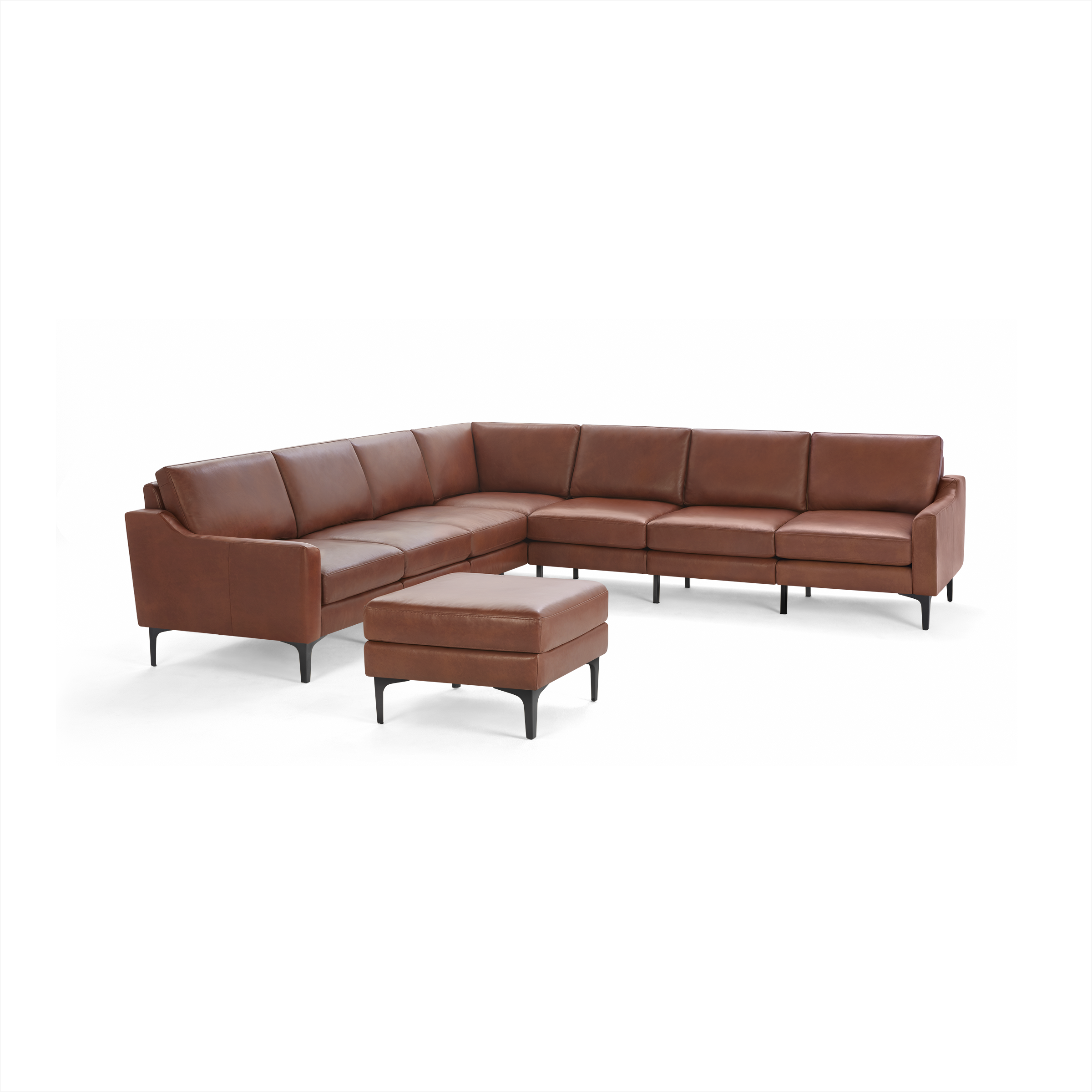 Modern brown leather L-shaped sectional sofa with matching ottoman, sleek black legs, and cushioned seats and backs.
