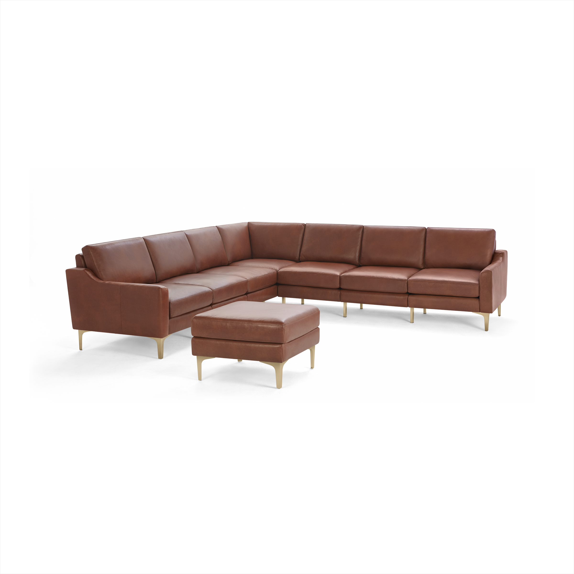Large modern L-shaped sectional sofa with brown leather upholstery and matching ottoman, supported by light wooden legs.