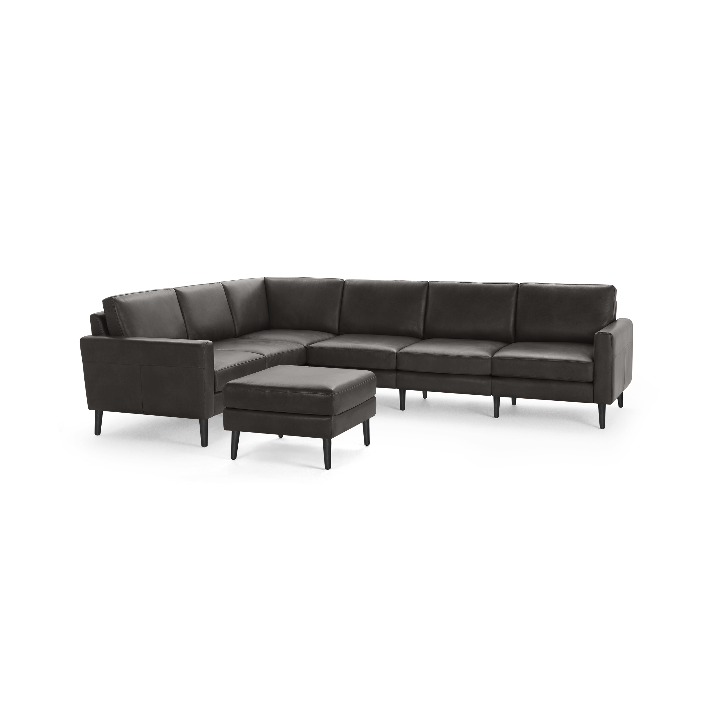 Modern dark gray leather sectional sofa with clean lines, low back cushions, and a matching ottoman on slender black legs.
