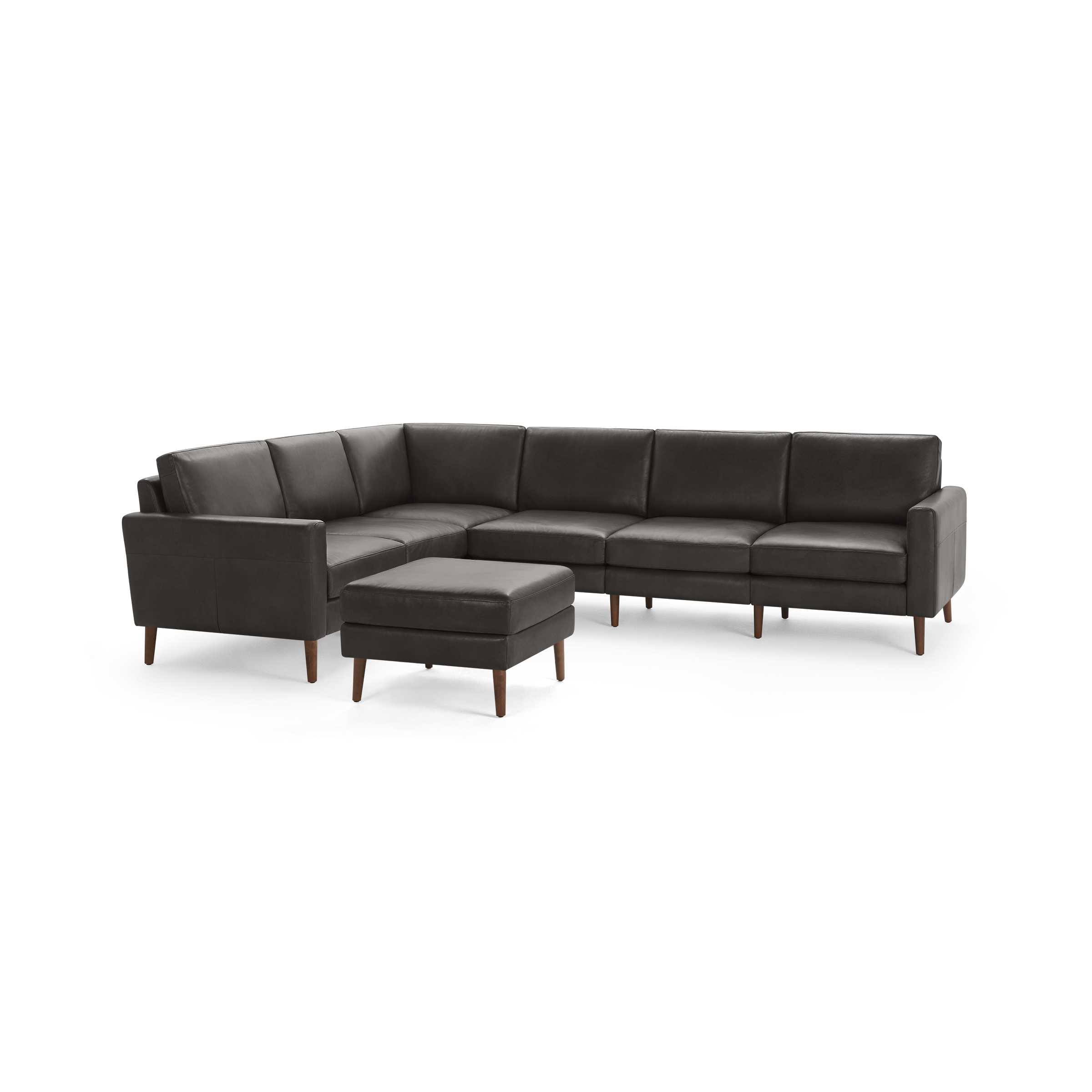 Dark gray leather L-shaped sectional sofa with wooden legs and matching square ottoman, modern, sleek design.
