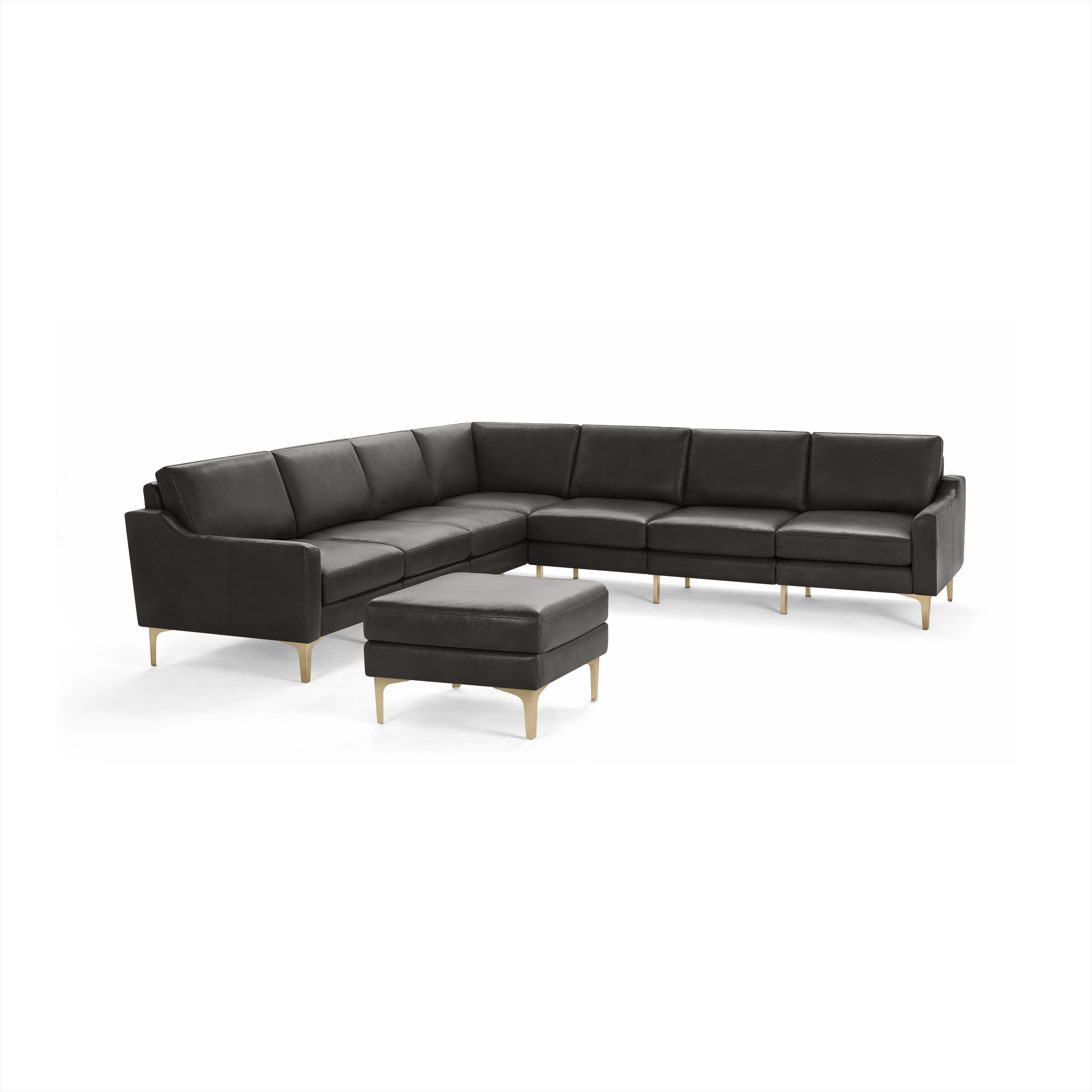 Large L-shaped dark gray leather sectional sofa with matching ottoman, featuring sleek gold metal legs.