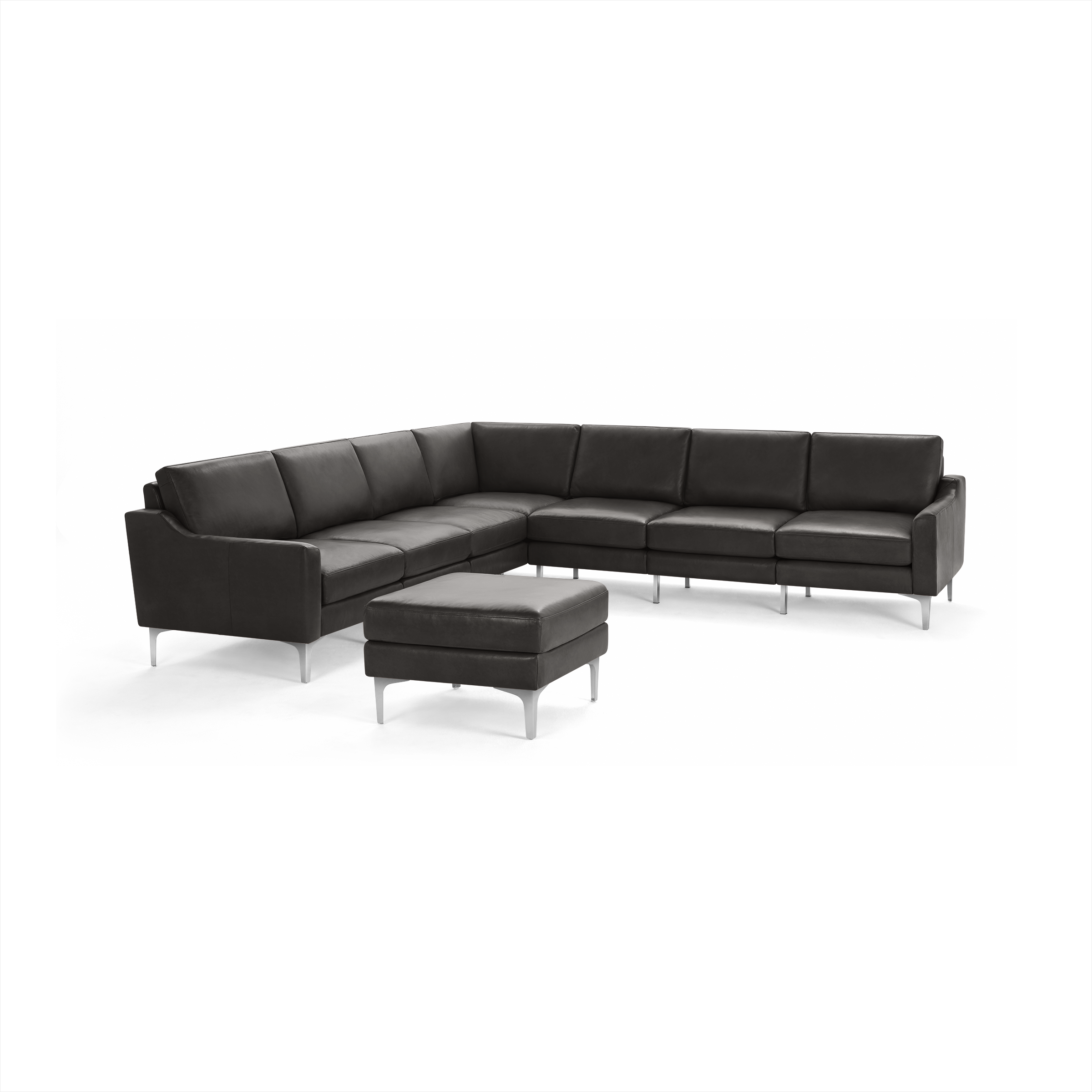 Modern black leather sectional sofa with matching ottoman, sleek metal legs, and cushioned seats and backrests.