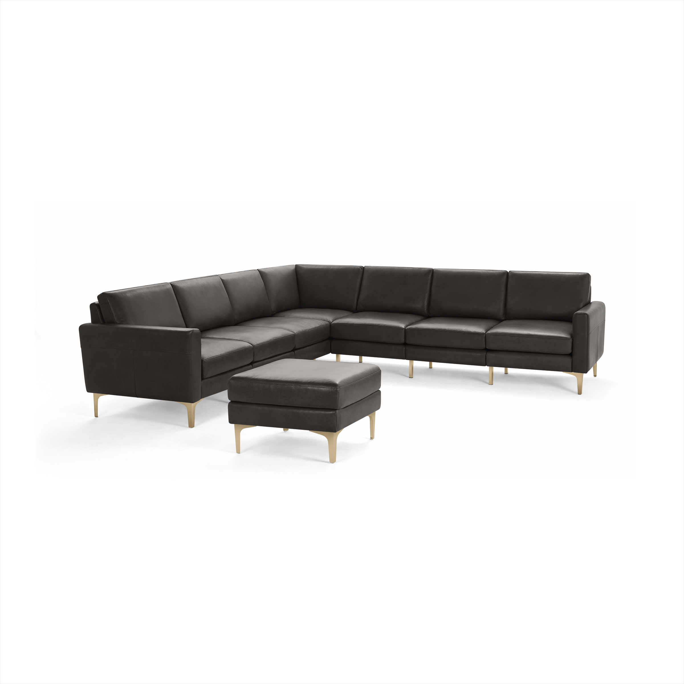 Dark gray leather sectional sofa with matching ottoman, featuring clean lines and light wooden legs.
