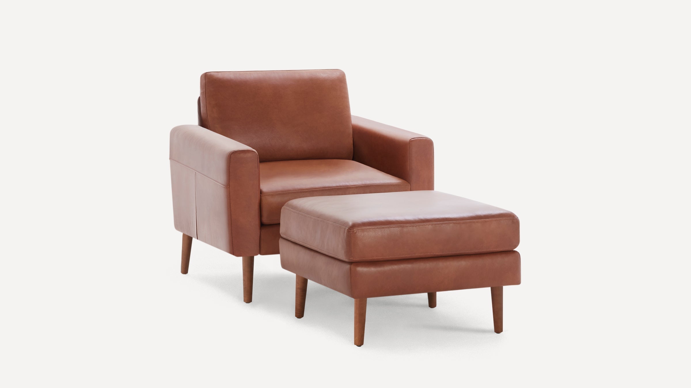 Modern mid-century style brown leather armchair with matching ottoman, featuring wooden tapered legs and clean lines.