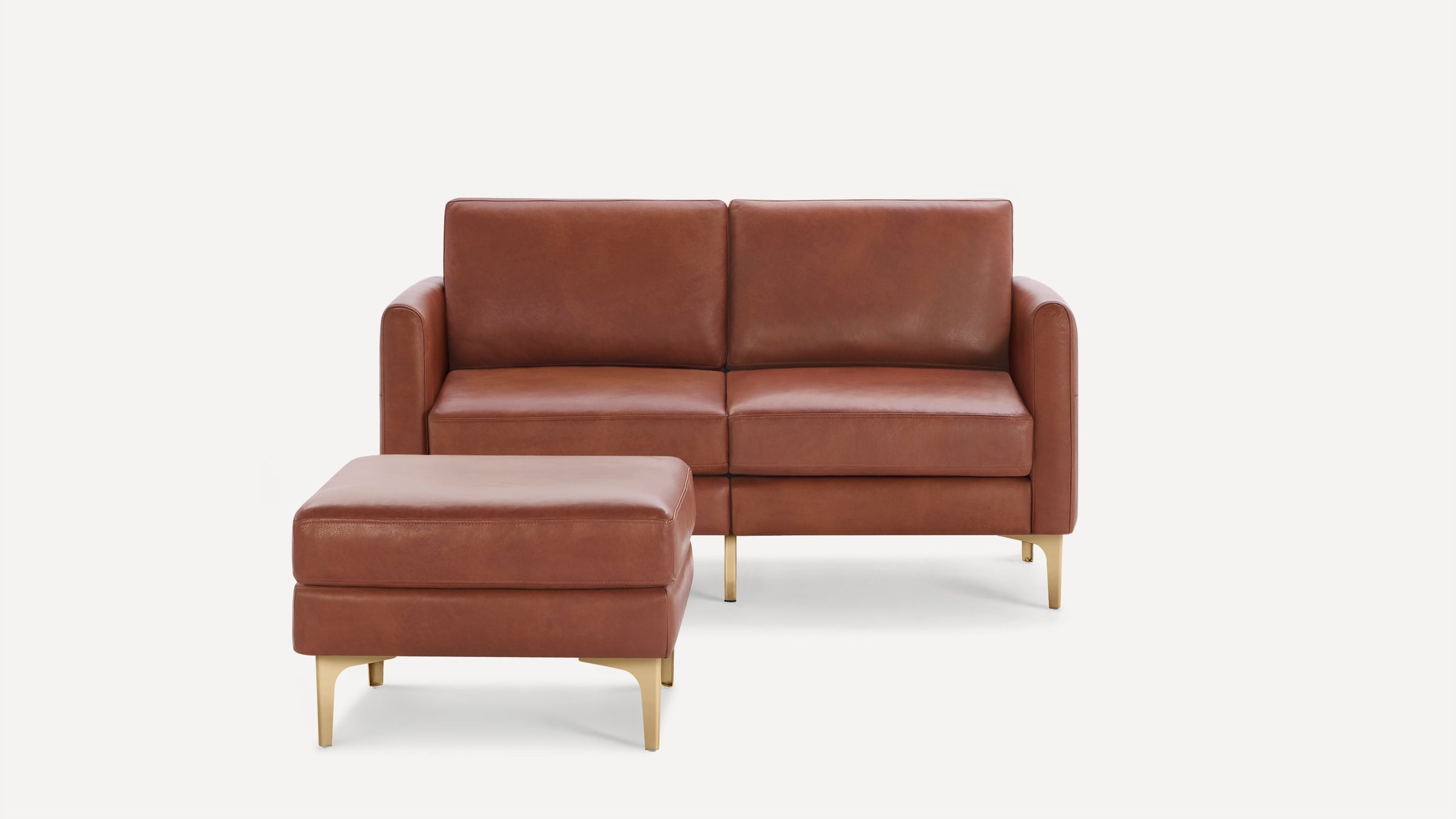 Brown leather loveseat sofa with matching ottoman, featuring clean lines and gold metal legs on a white background.