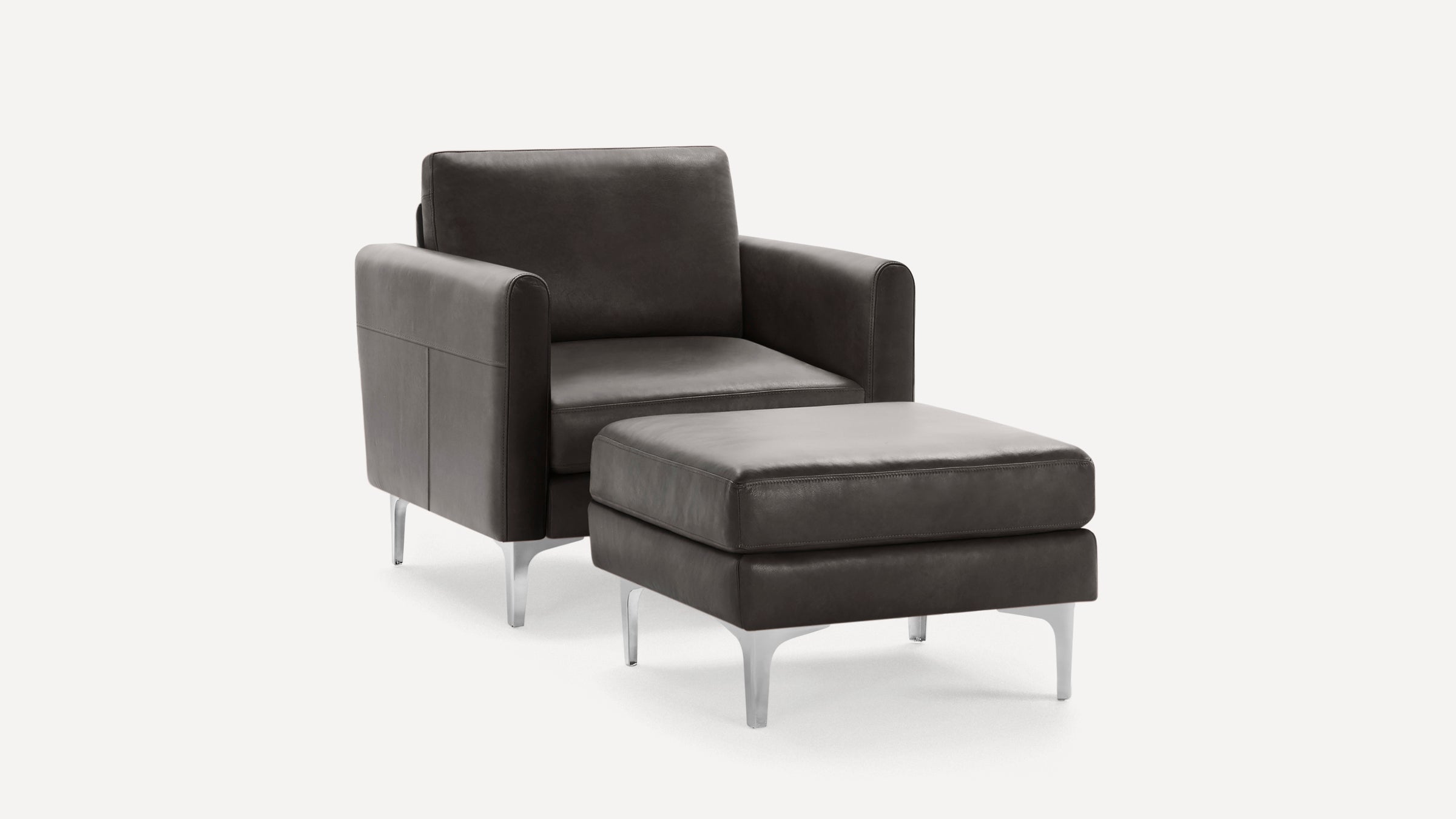 Modern dark gray leather armchair with matching ottoman, featuring sleek metal legs and minimalist design.
