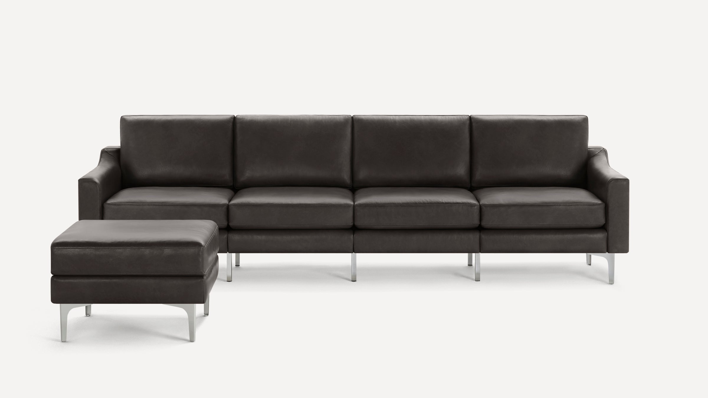Modern dark gray leather sectional sofa with clean lines, metal legs, and matching ottoman.