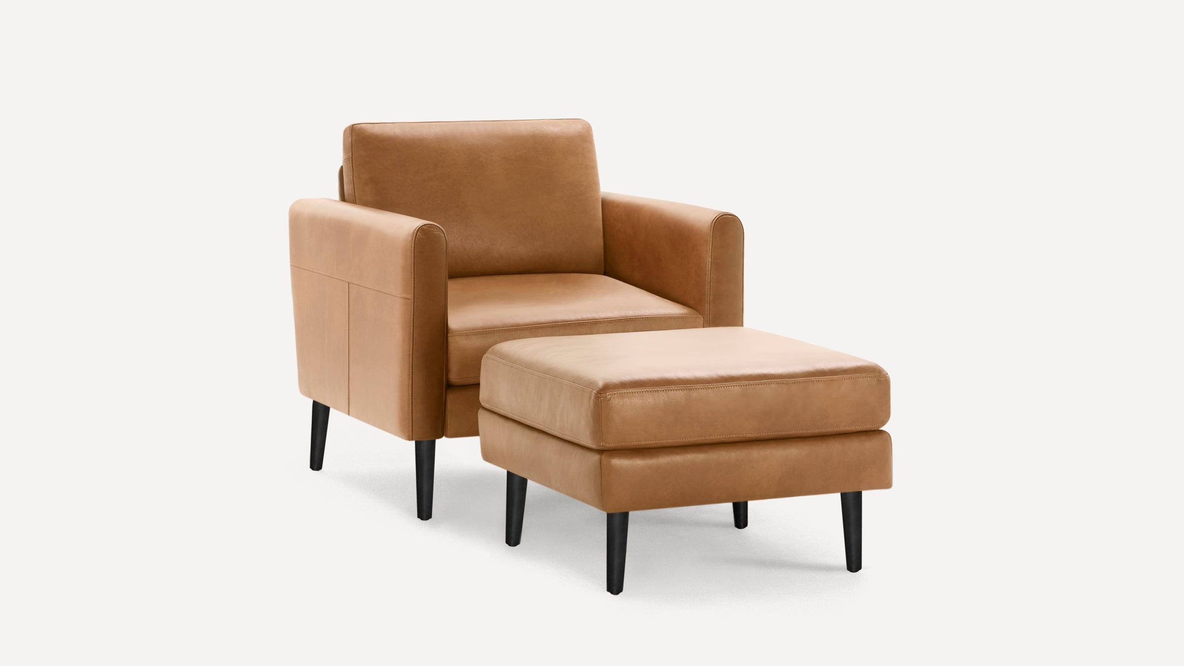 Modern tan leather armchair with matching ottoman, both featuring black tapered legs and clean, minimalist design.