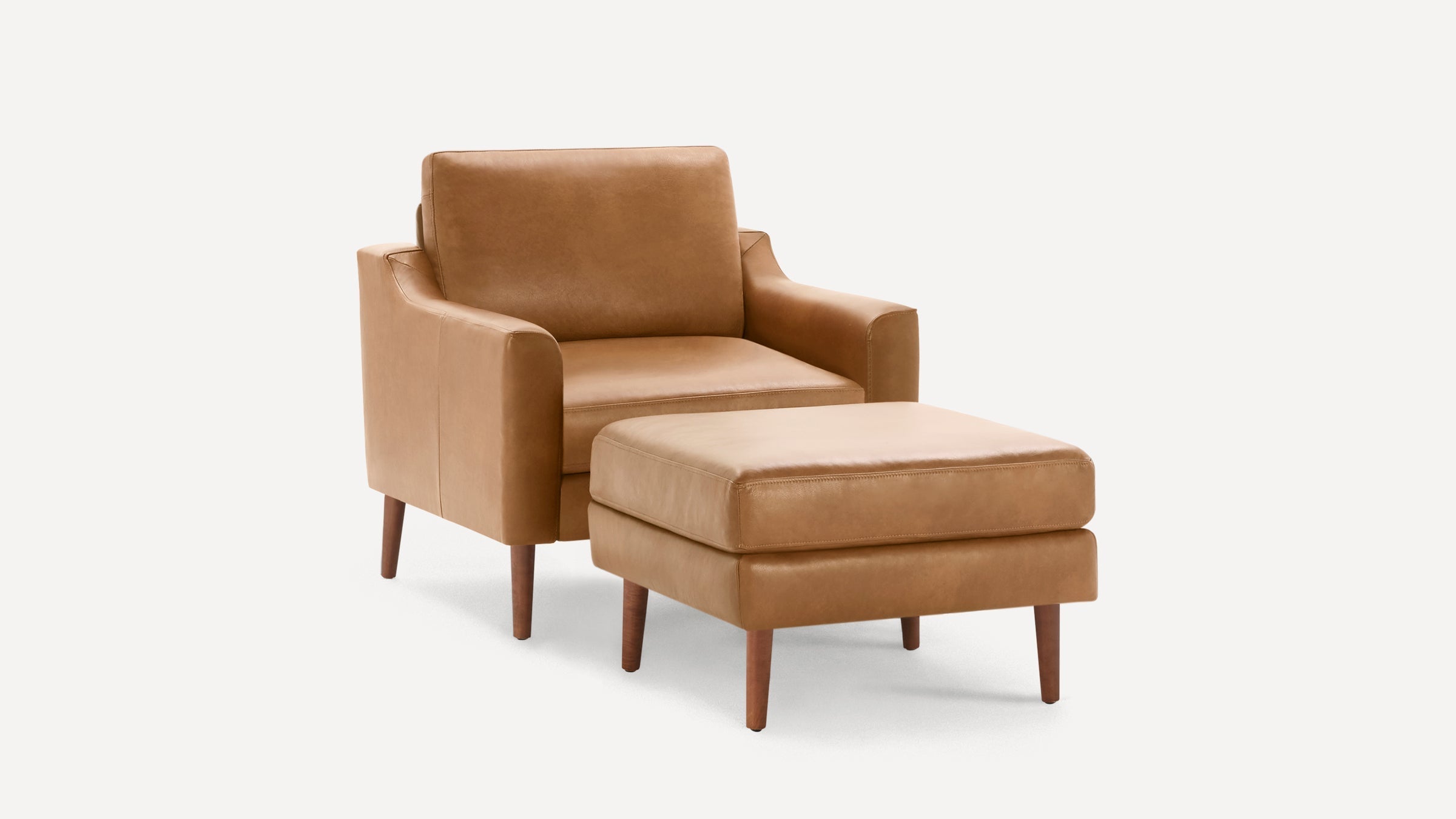 Modern tan leather armchair with matching cushioned ottoman, both featuring wooden legs and clean lines.