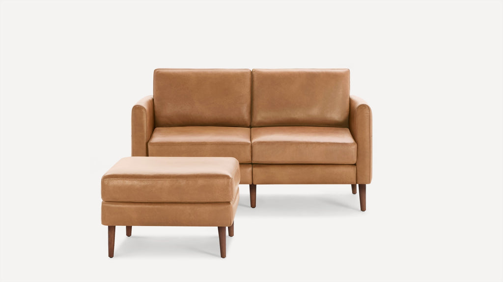 Light brown leather loveseat sofa with square arms paired with matching cushioned ottoman, both featuring tapered wooden legs.