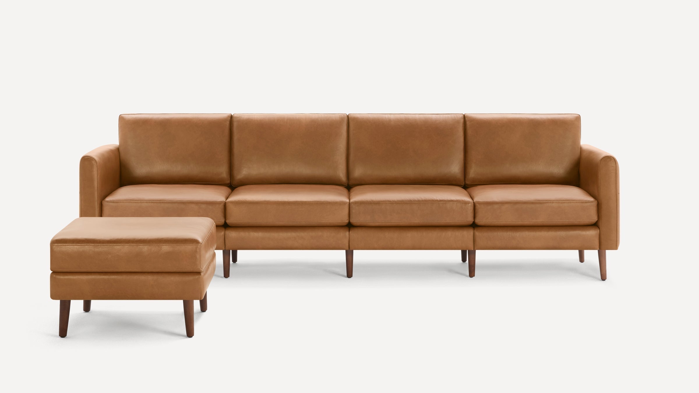 Modern tan leather sectional sofa with clean lines, cushioned seats, and matching ottoman on wooden legs.