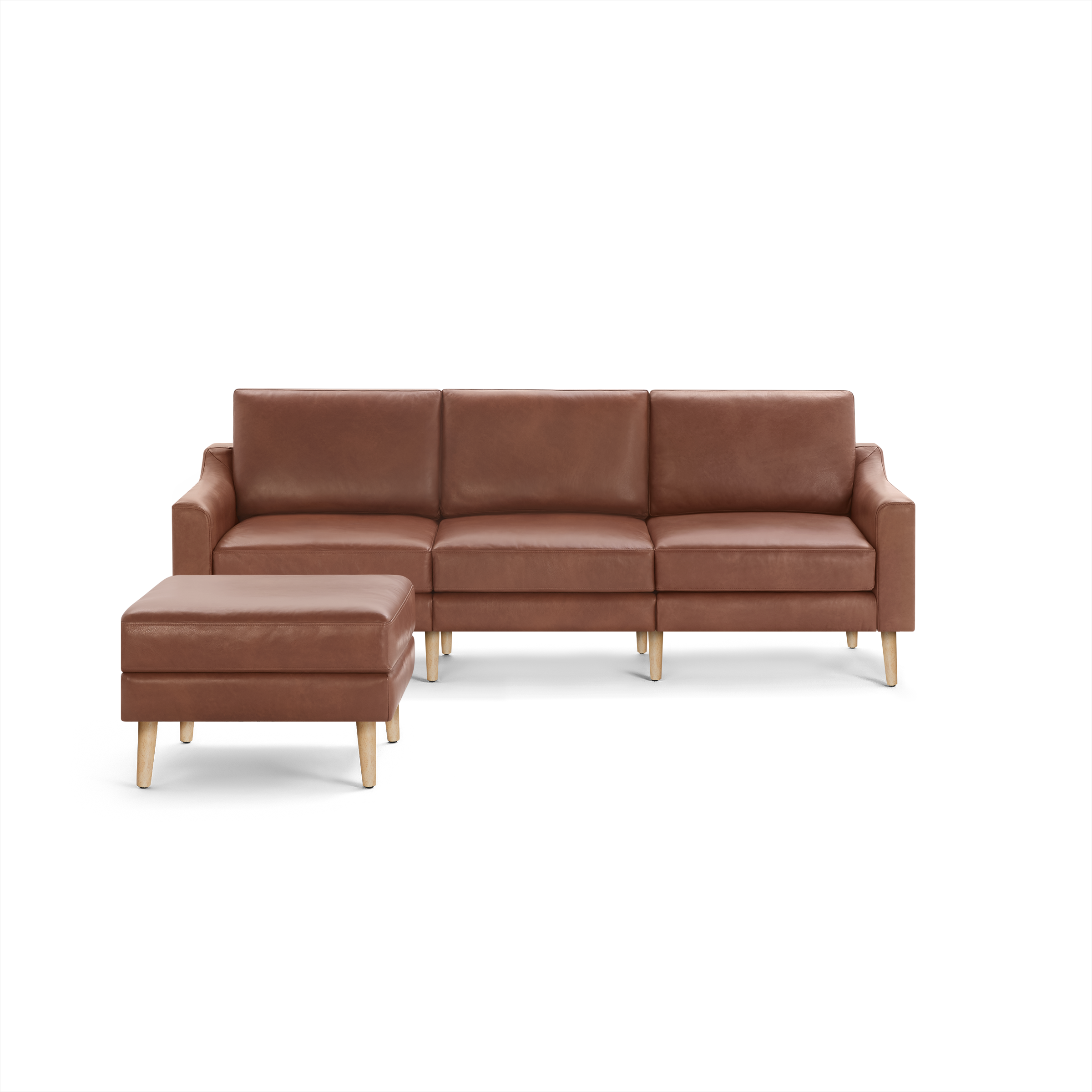 Brown leather sectional sofa with three cushions and matching ottoman, supported by light wooden legs.