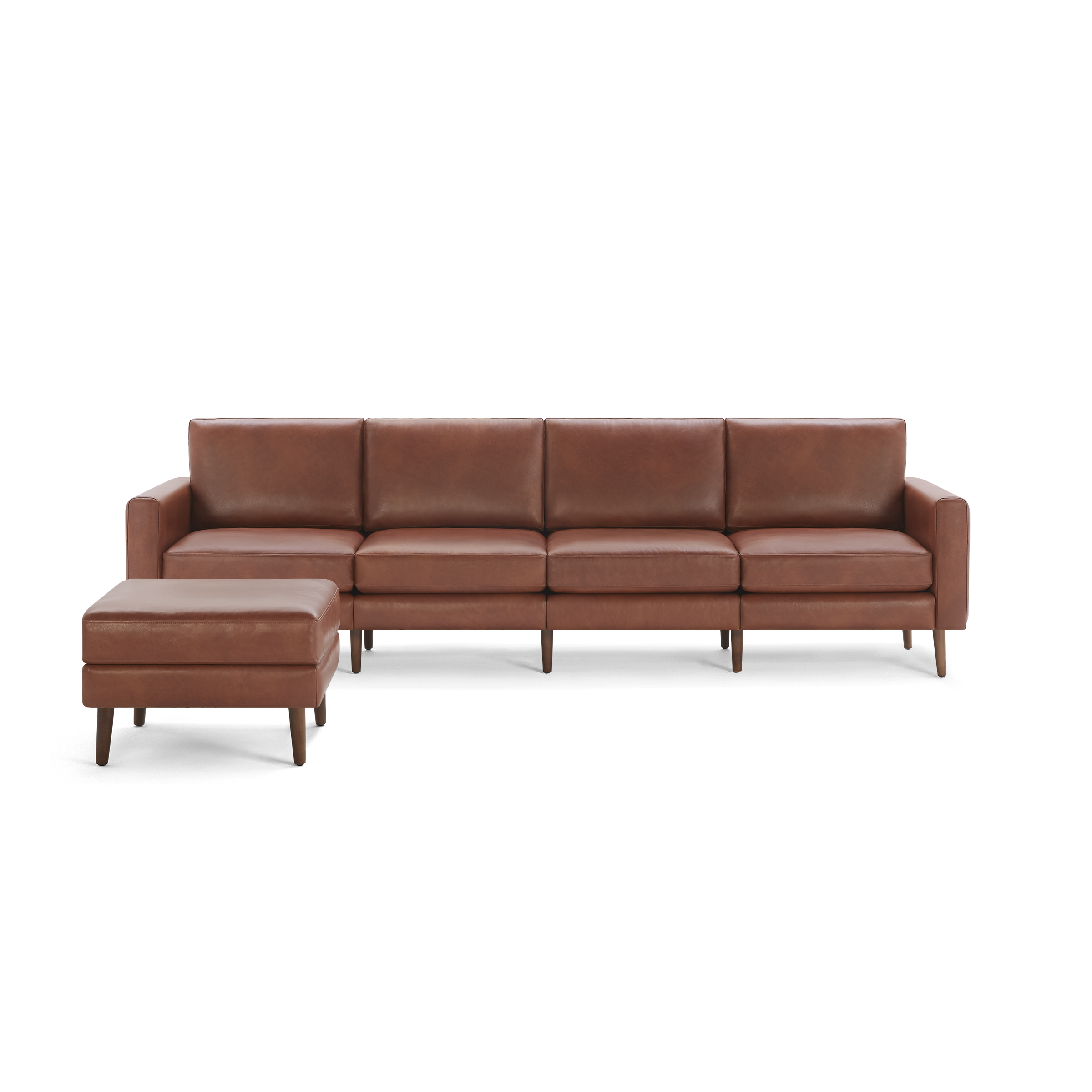 Brown leather sectional sofa with four seat cushions and matching ottoman, supported by wooden legs.