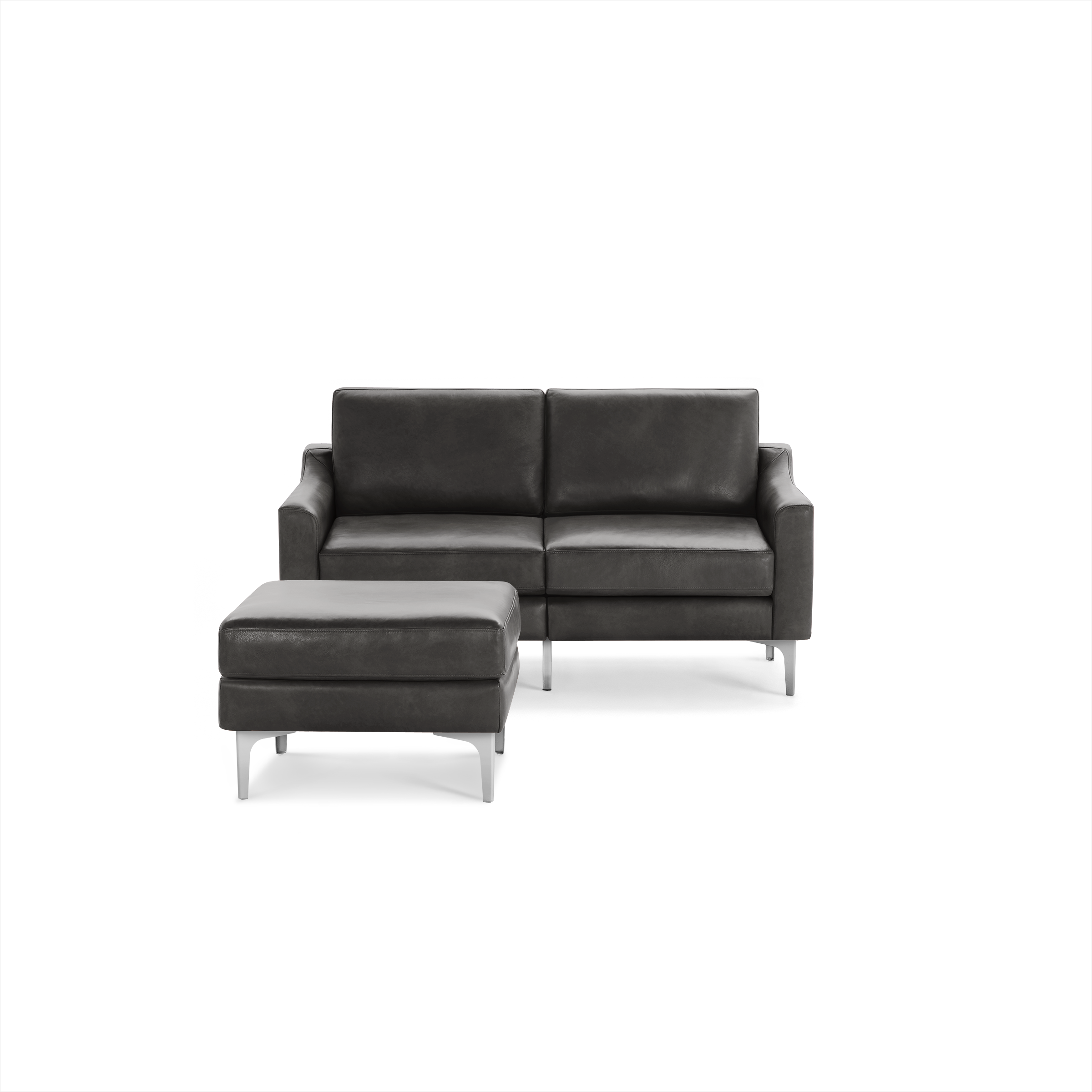 Dark gray leather loveseat sofa with matching ottoman, supported by sleek metallic legs, modern design.