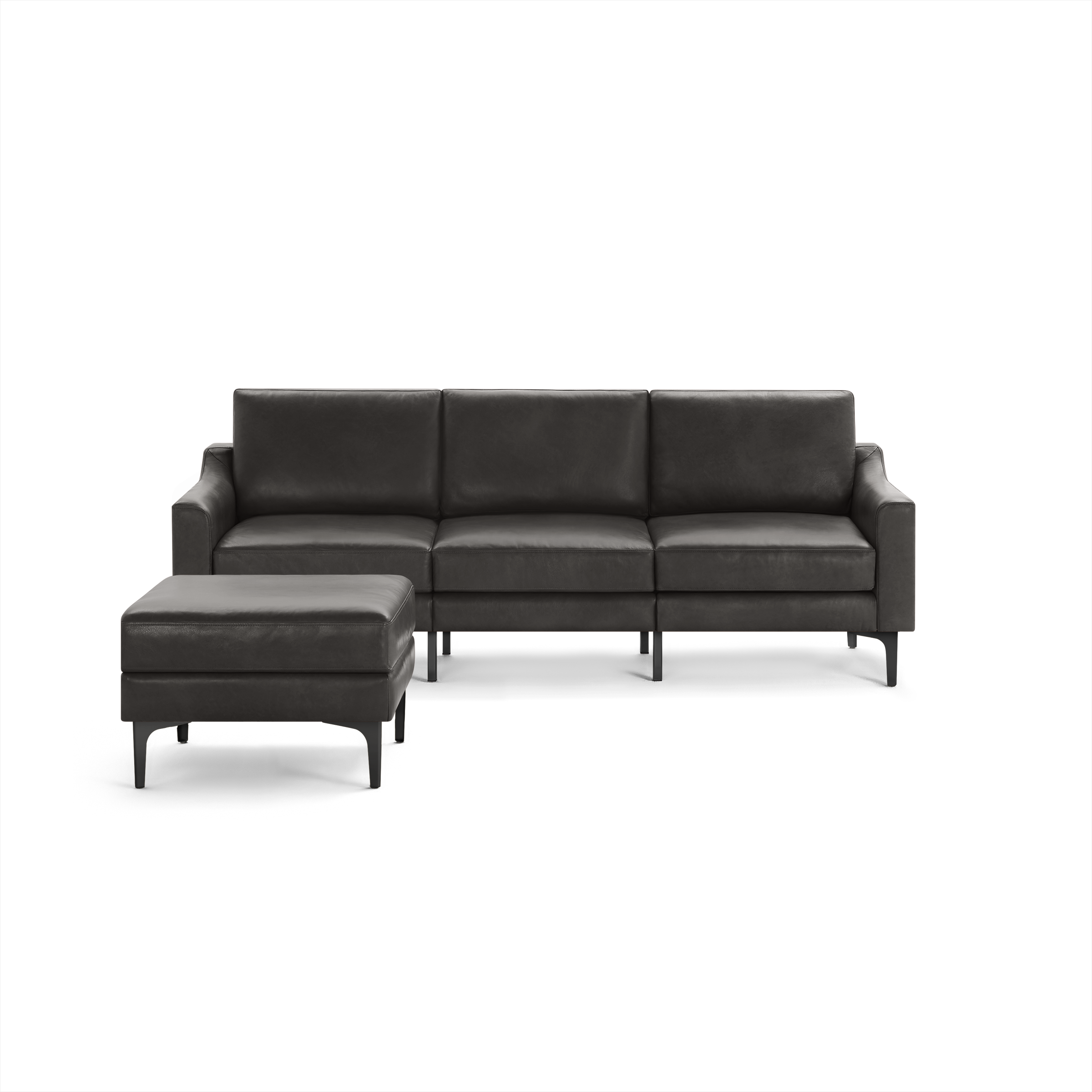 Dark gray leather sectional sofa with three cushioned seats and a matching ottoman, modern design with slim angled legs.